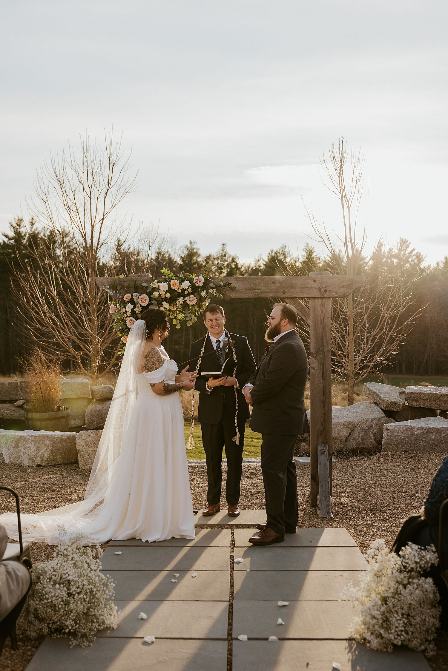 Couple exchanging vows at their New Hampshire fall wedding ceremony outside
