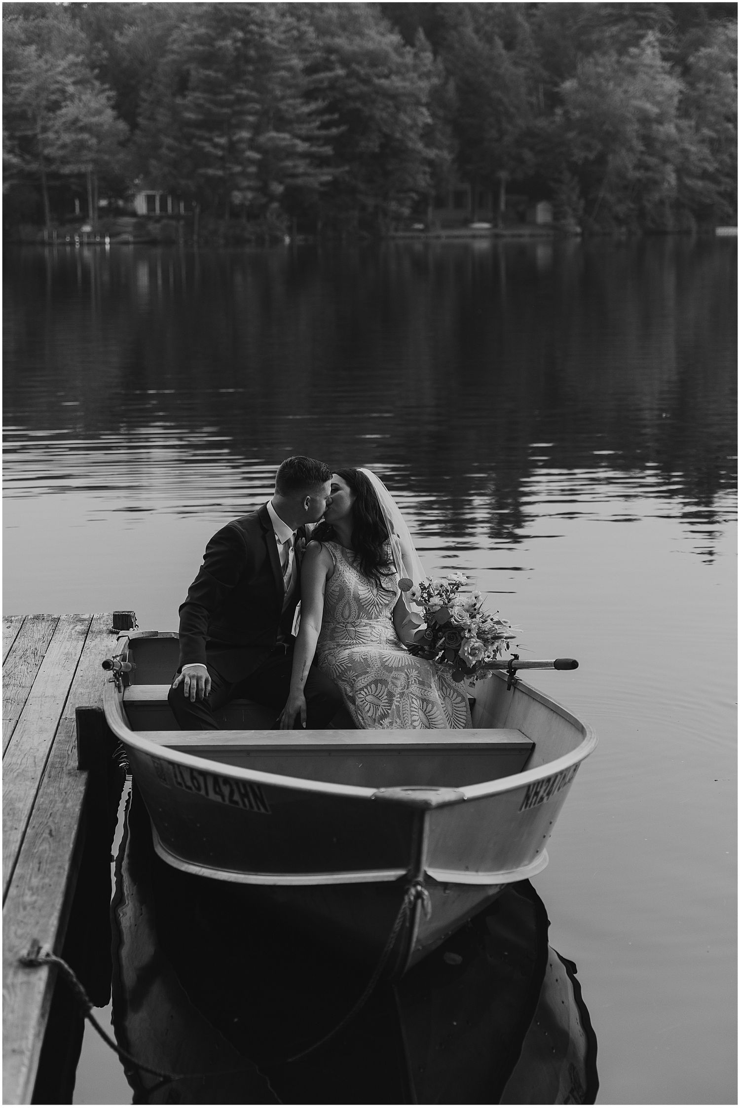 Couple in a row boat at their lakeside wedding in NH