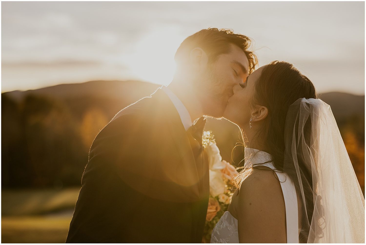 Intimate sunset wedding portrait with warm golden backlighting.