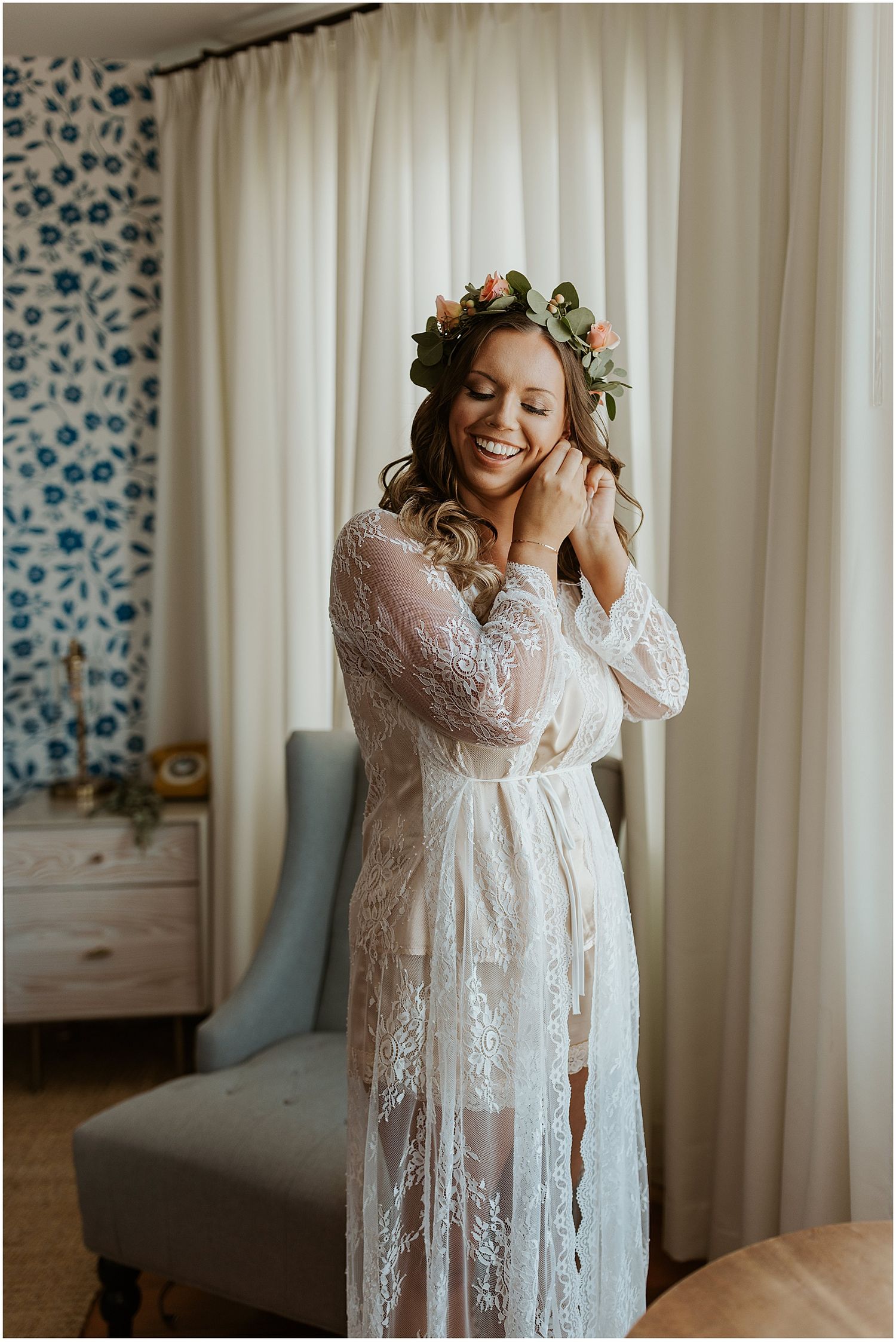 Lace bridal robe and floral crown in a light-filled getting ready room.