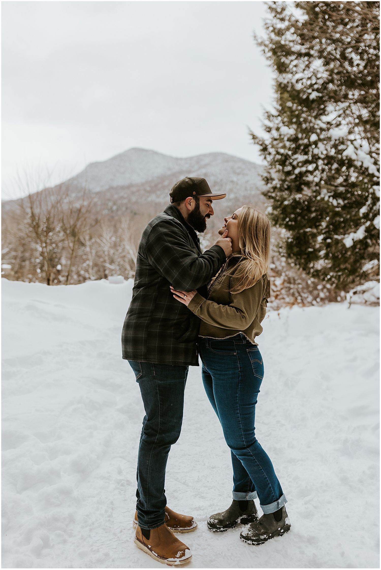 NH couple taking engagement photos in the White Mountains wearing winter engagement photo outfits