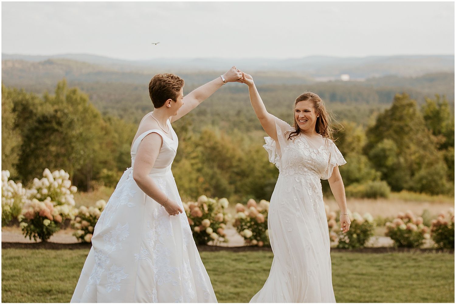 Scenic outdoor celebration in a hilltop garden with rolling mountains in the background.