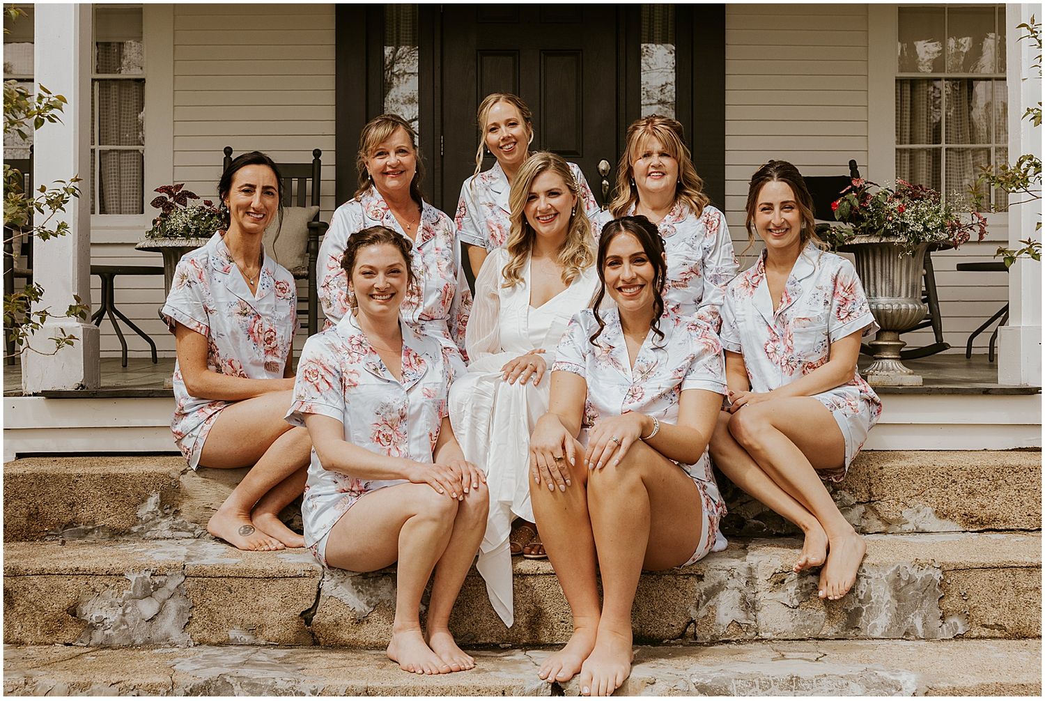 A group relaxes on stone steps wearing matching floral robes.