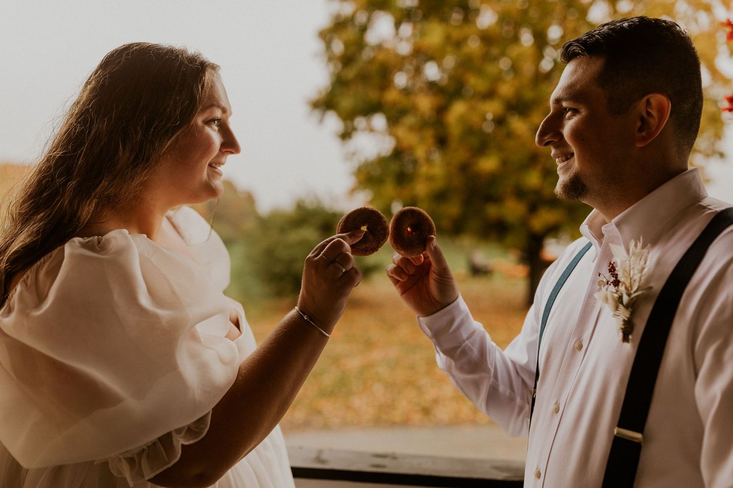 Warm sunset light illuminates a romantic outdoor wedding scene.