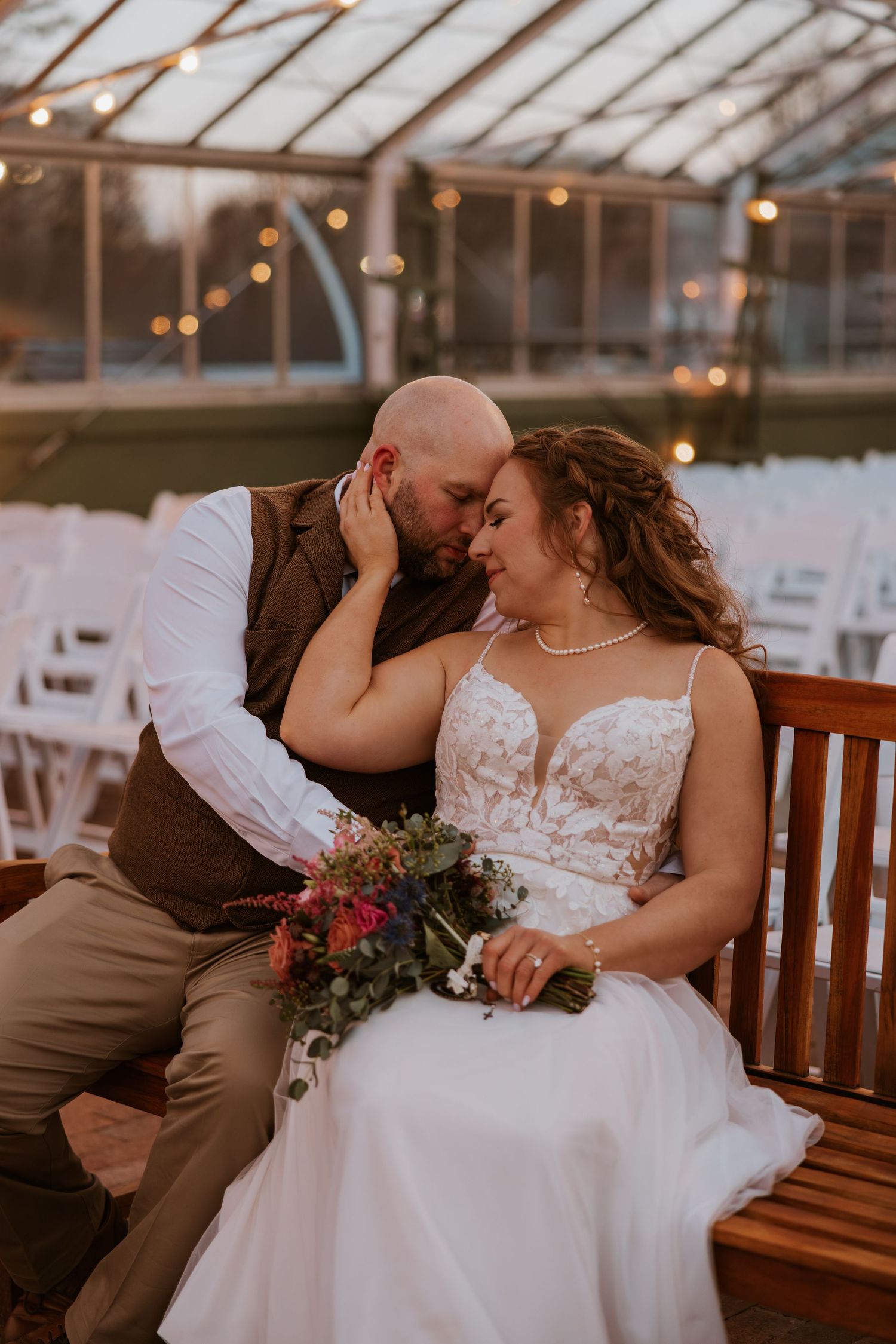 Romantic couple shares intimate moments on a wooden bench at sunset.