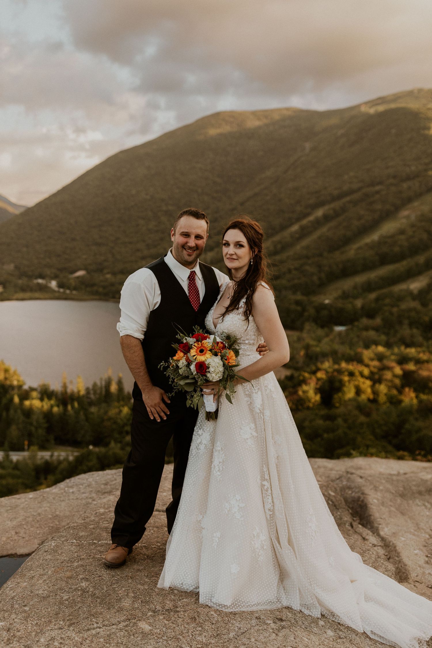 Newlyweds posing for a portrait on Artist Bluff in Franconia New Hampshire.