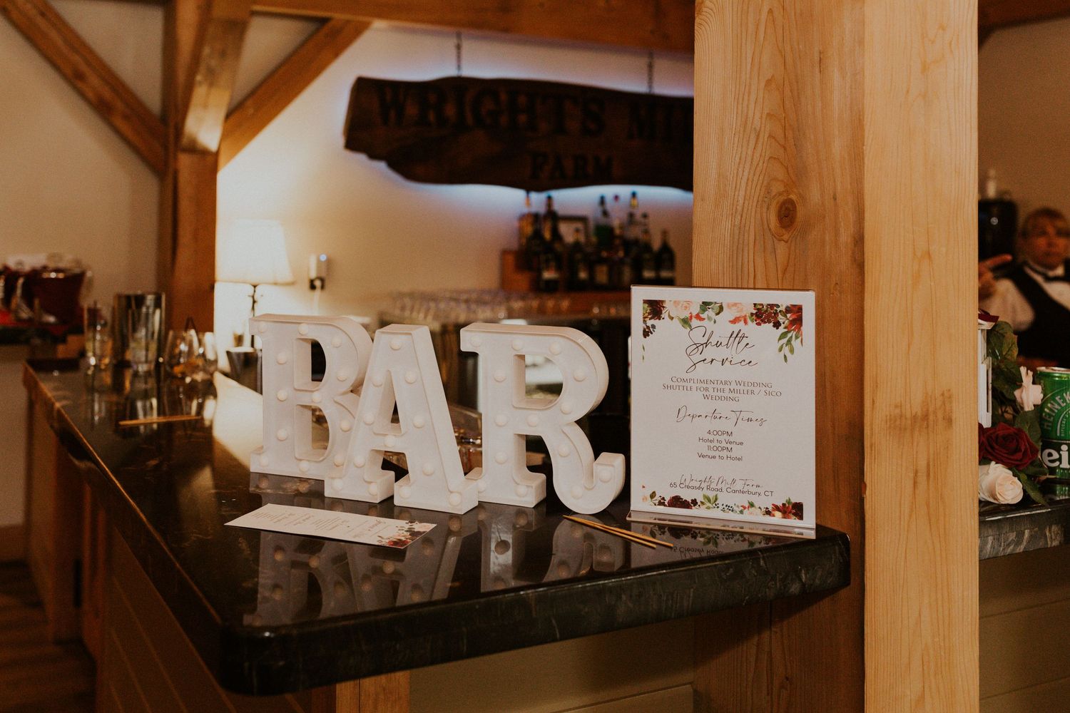 Rustic barn reception area with wooden beams and decorative signage.