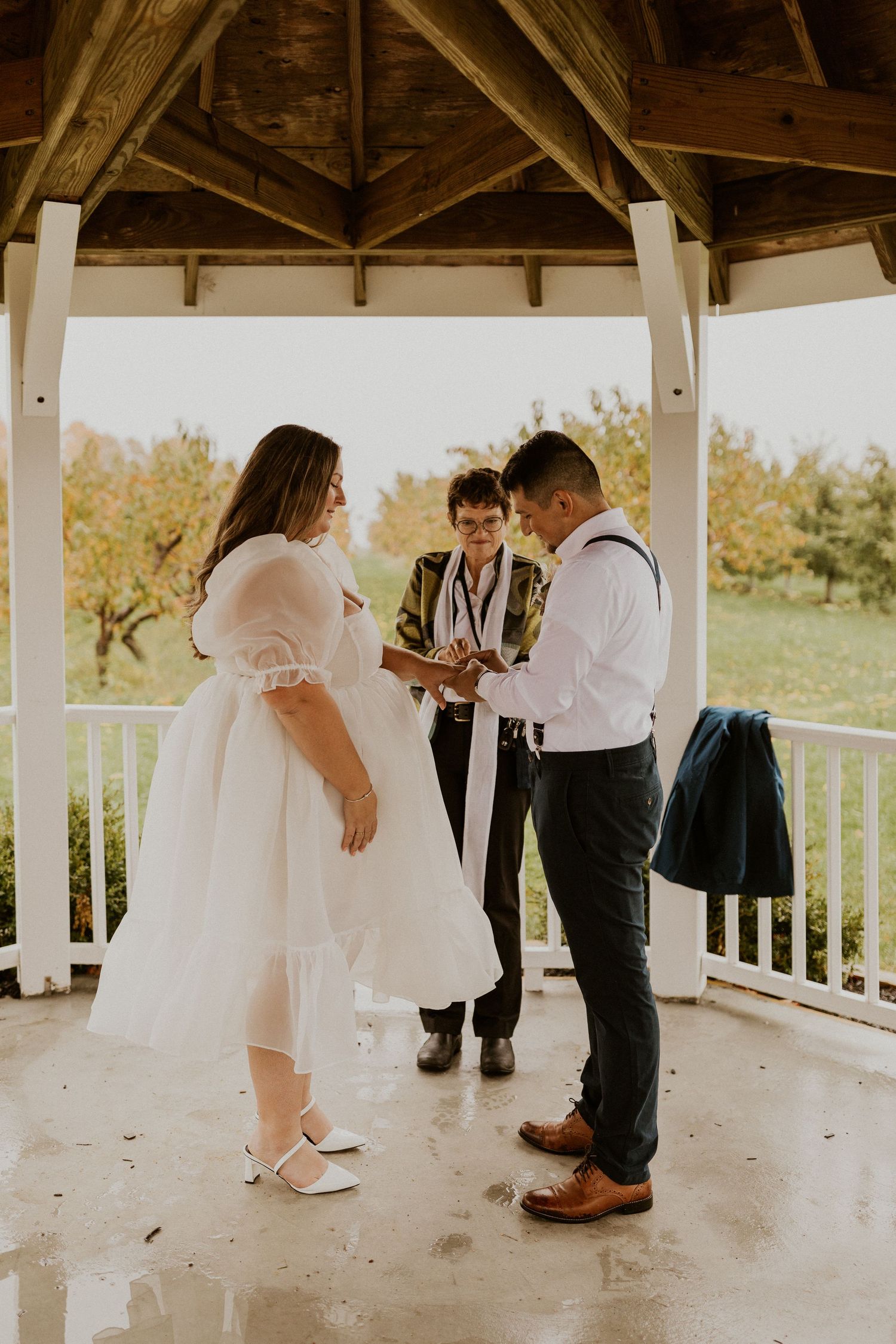 Terise and Jose holding hands during their ceremony at Carter Hill Orchard in Concord New Hampshire.