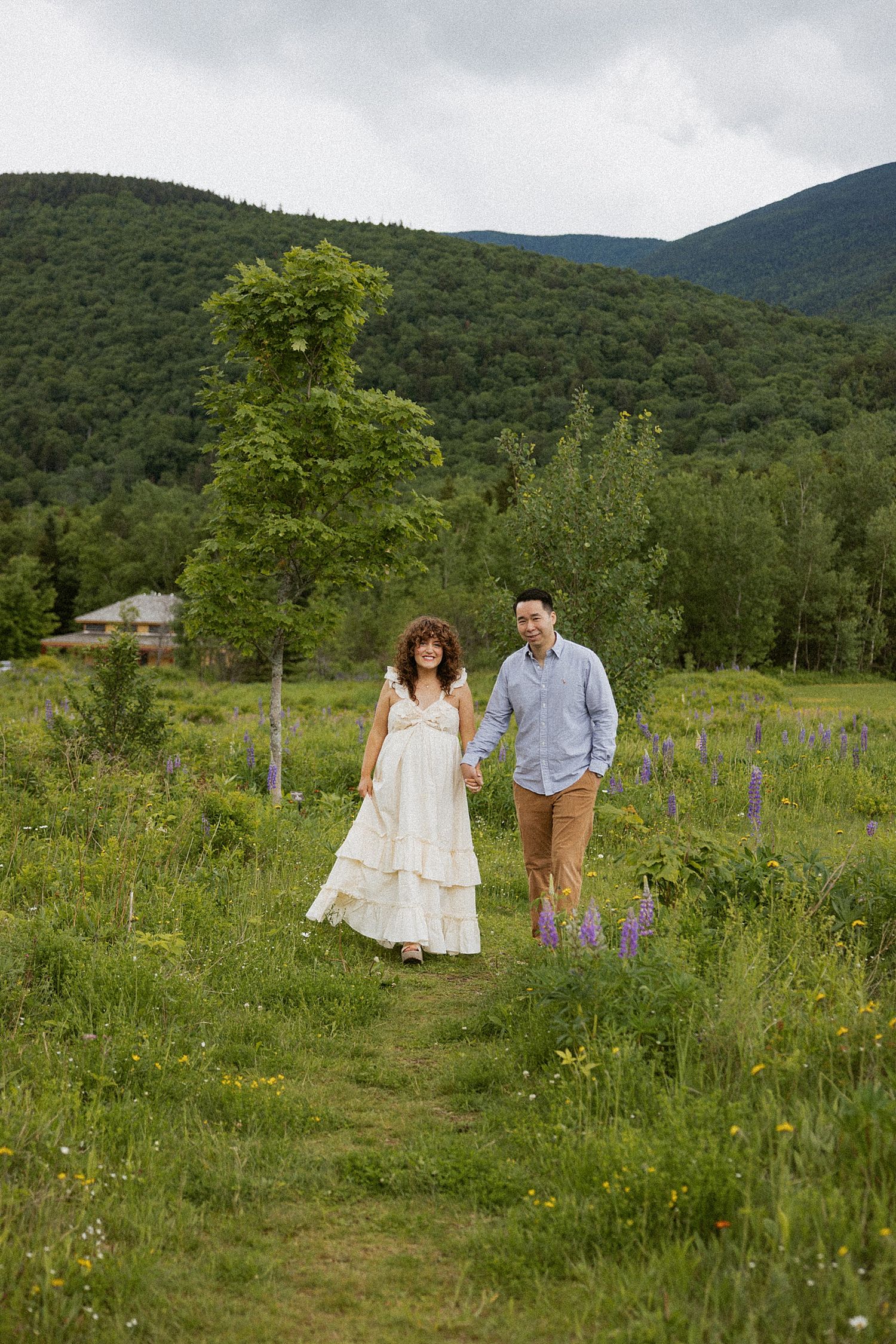 Pregnant couple taking motherhood photos in a field in New Hampshire