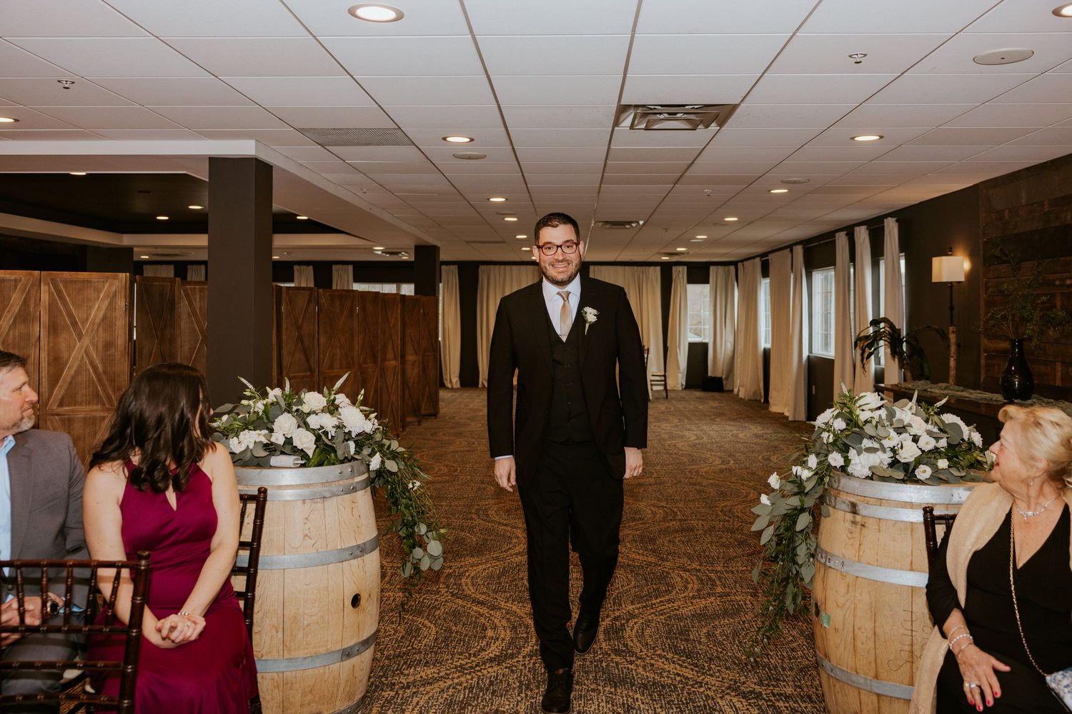 Indoor wedding ceremony setup with elegant decor and guests seated in rows at an event venue.