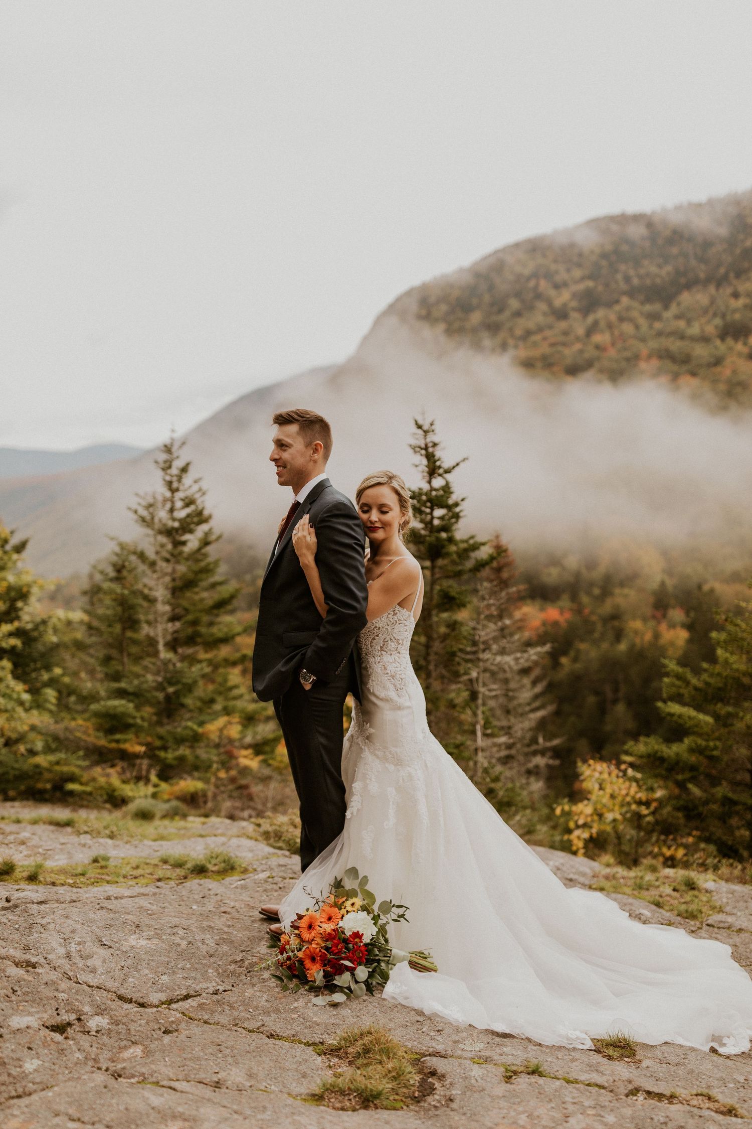 Newlyweds posing for mountaintop portraits in the White Mountain National Forest of New Hampshire.