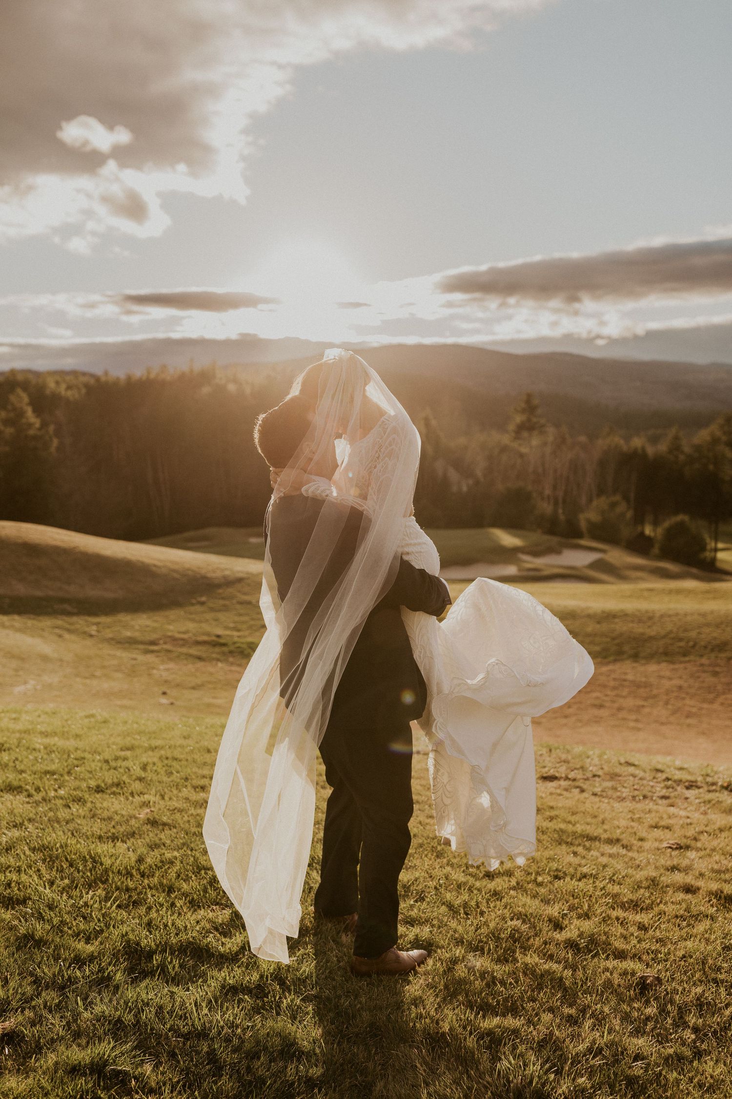 The groom picked up the bride and spun her in circles during golden hour at Owl's Nest Resort in Thornton New Hampshire.