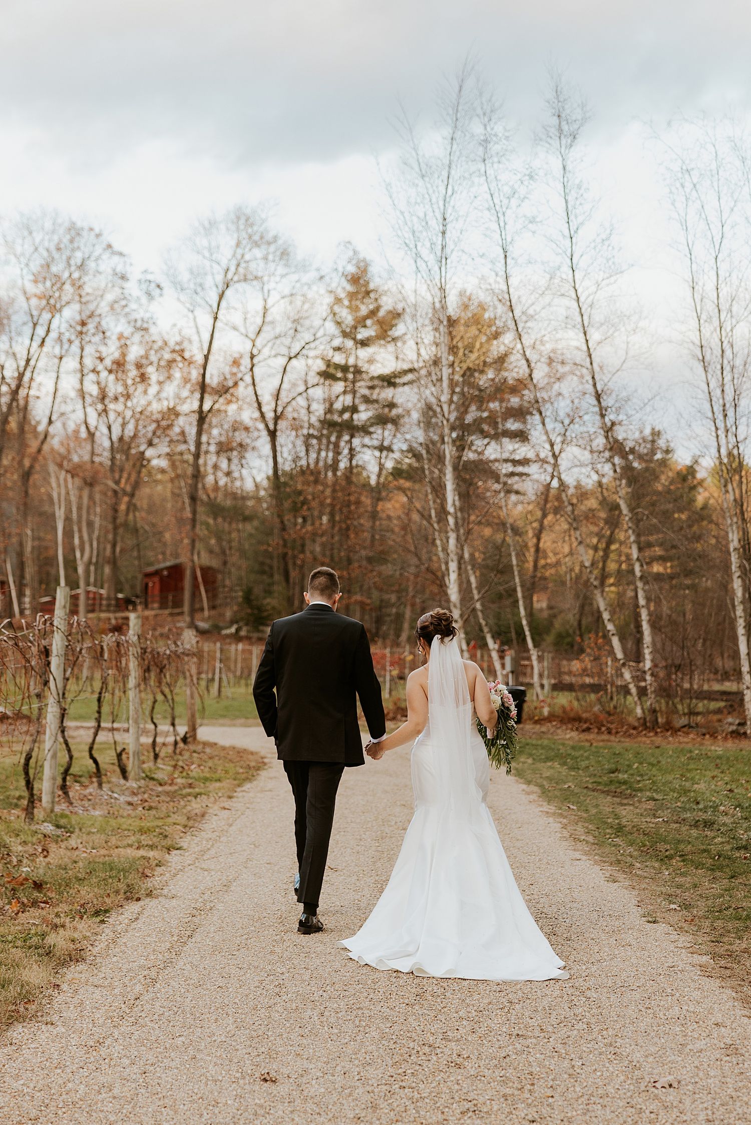 Bride and groom walking down a gravel path after their NH wedding ceremony