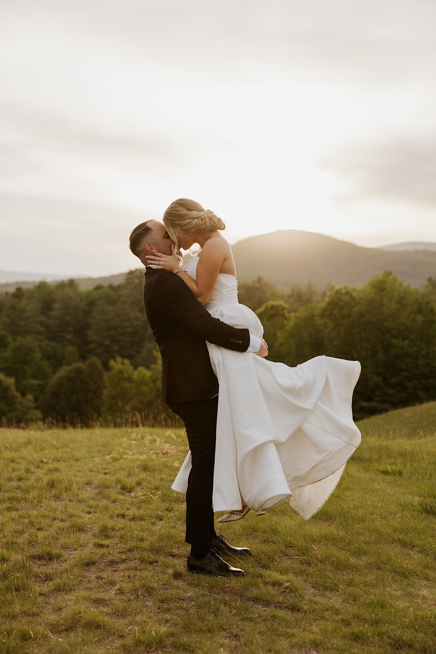 Bride and groom taking sunset portrait photos with the mountains in the background at the Owl's Nest Resort in NH