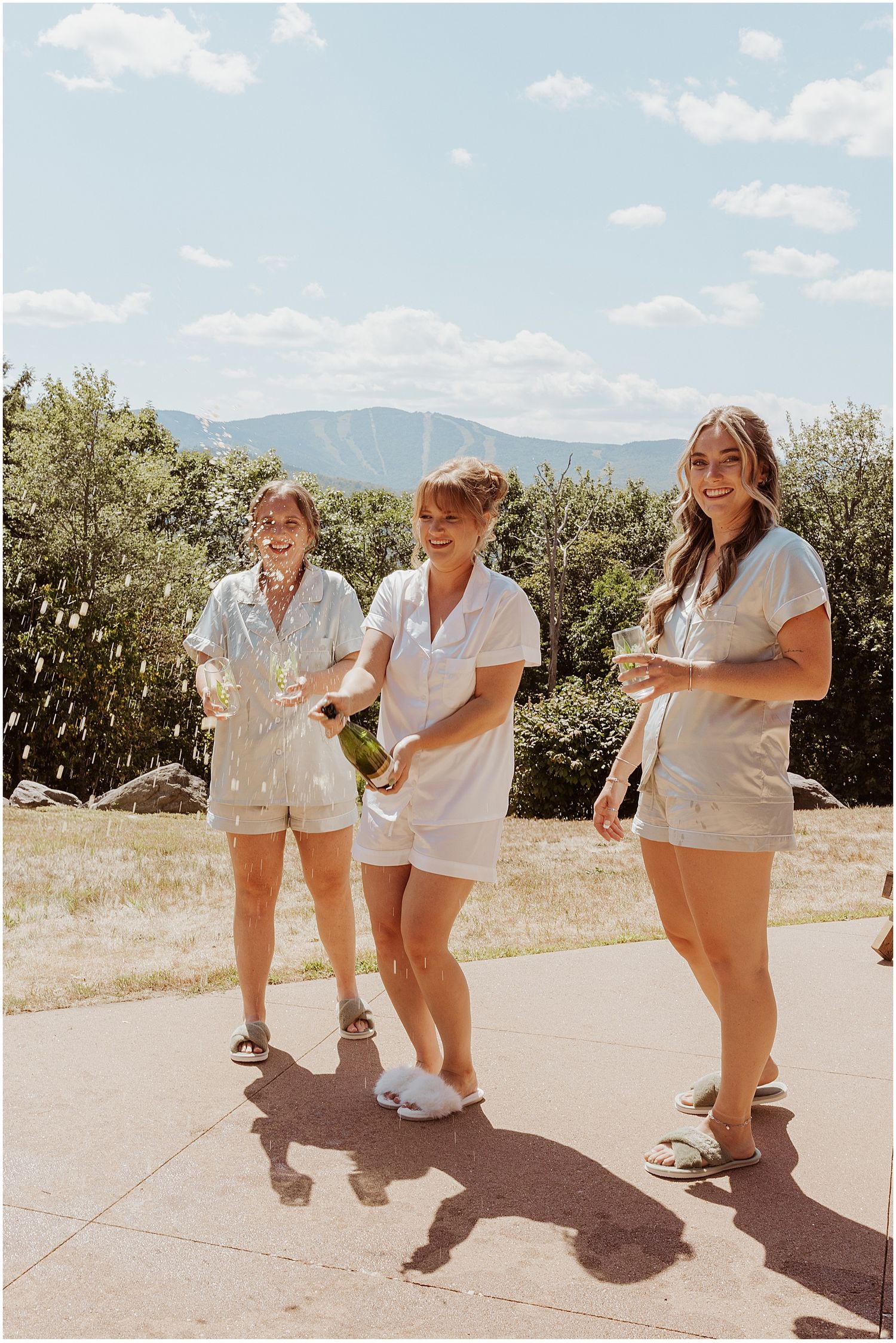 Bride and her bridesmaids popping champagne at her VRBO wedding in Maine