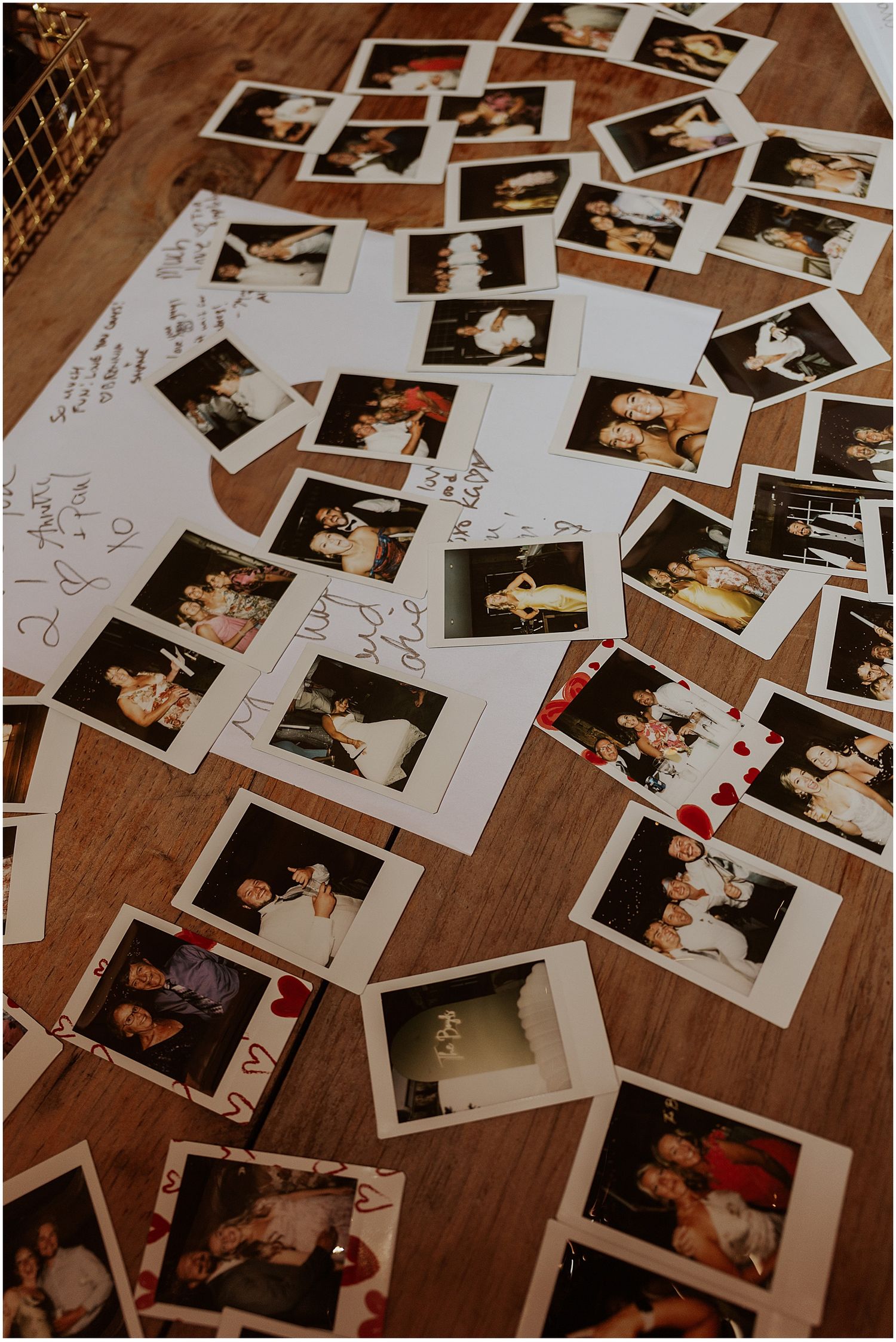 Collection of polaroid photos scattered on wooden surface from a wedding celebration.