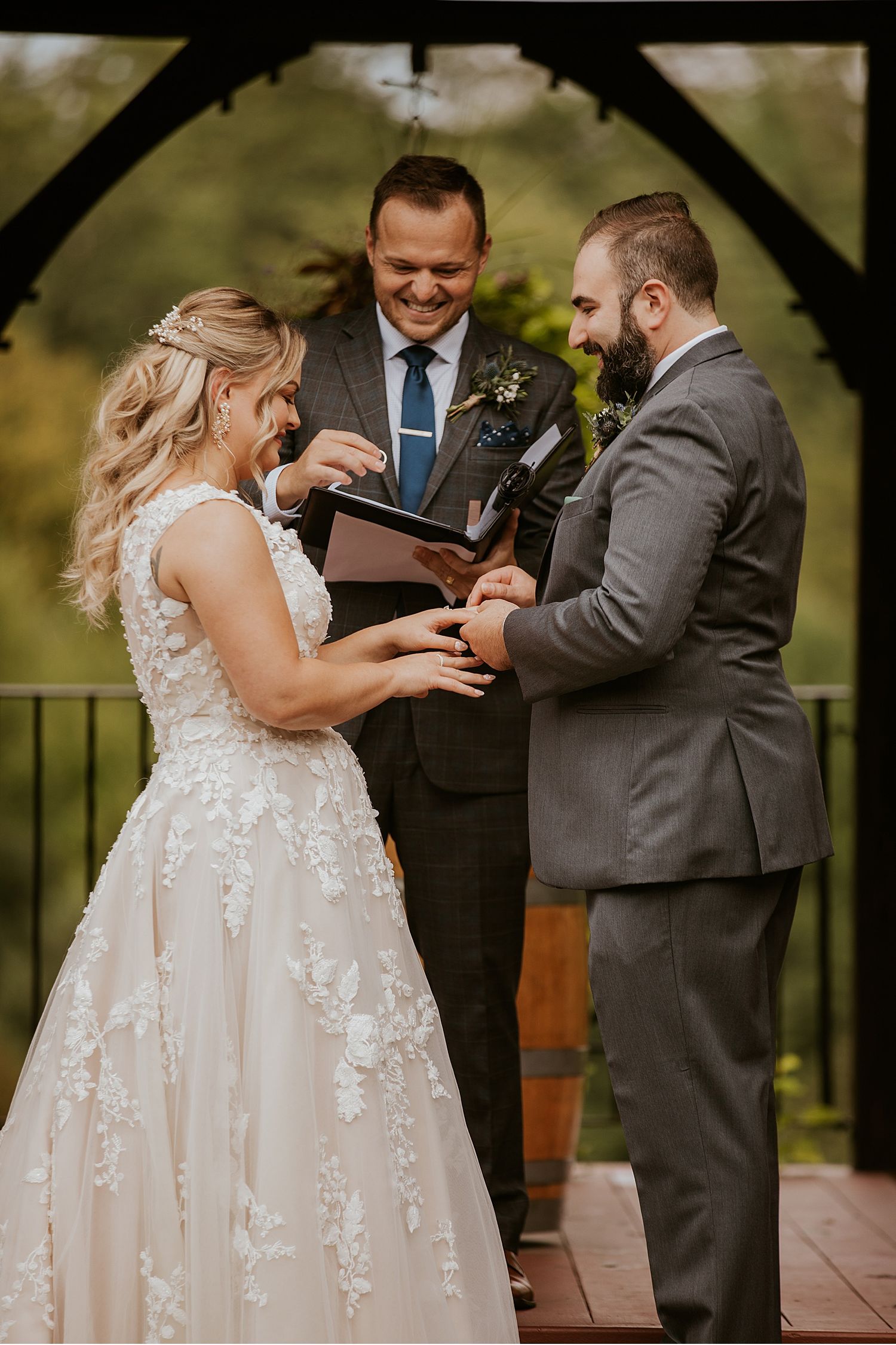 Emotional wedding ceremony exchange on an outdoor deck with floral decorations.