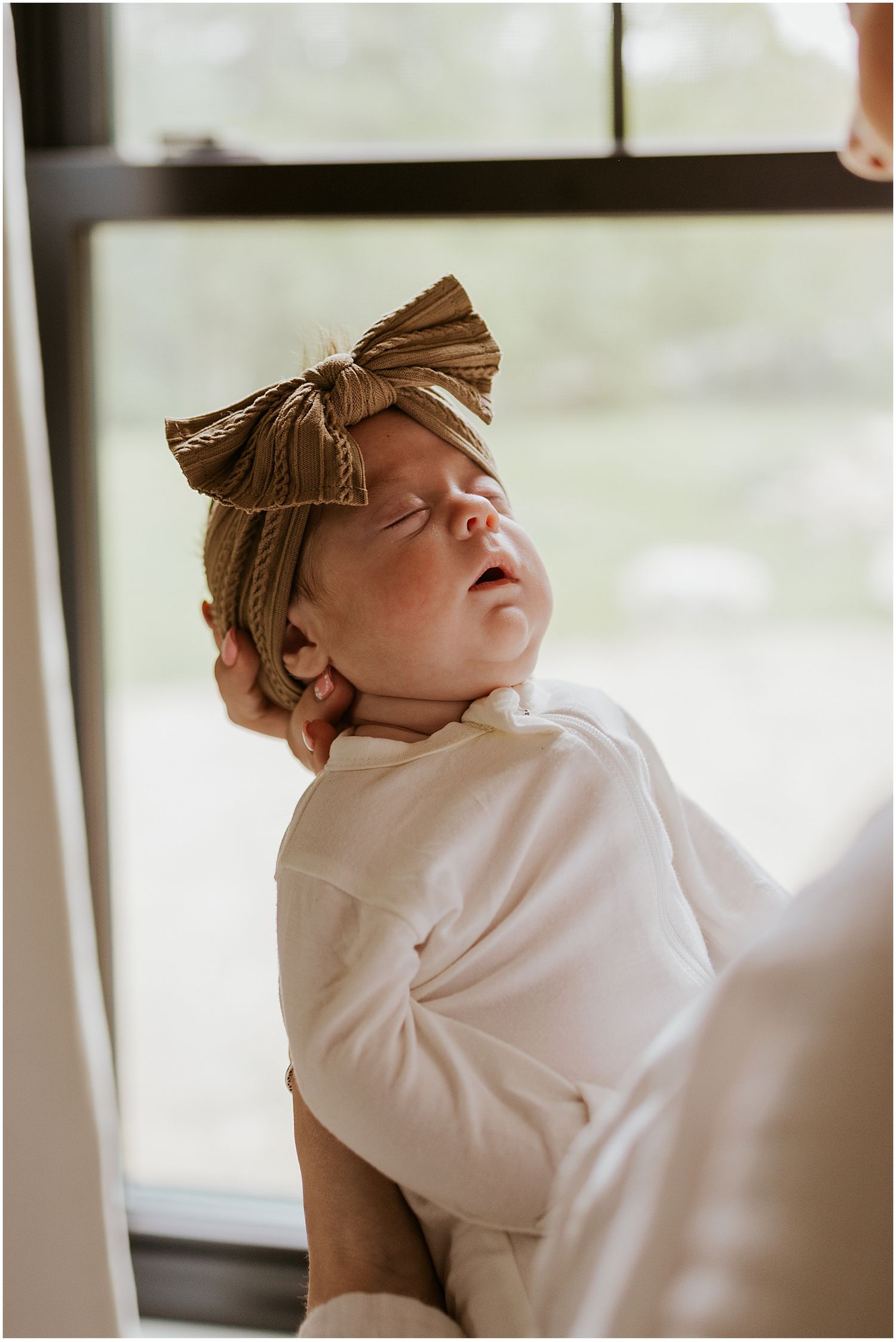 A newborn baby being held at home by her mom
