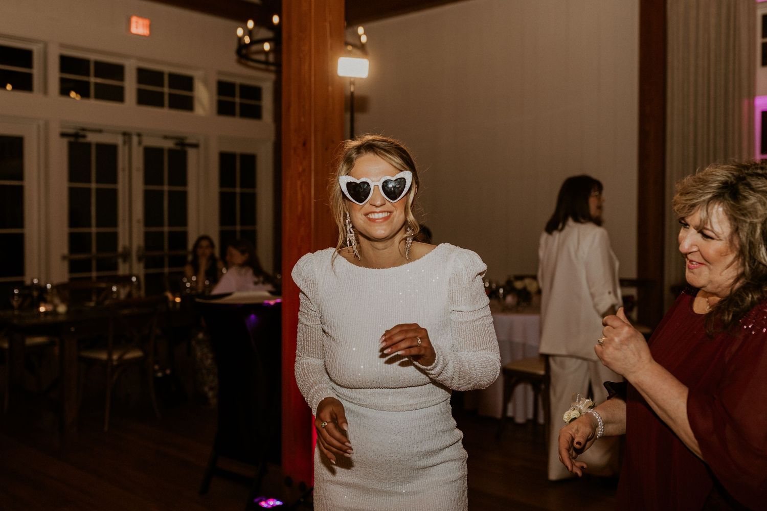 The bride dancing and enjoying the night with her sunglasses and glamorous reception dress!