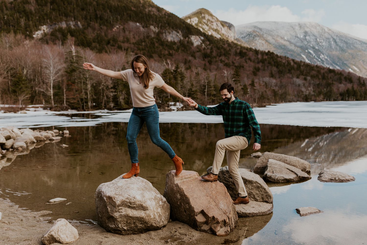 A happy couple standing in front of Echo Lake in Franconia Notch State Park