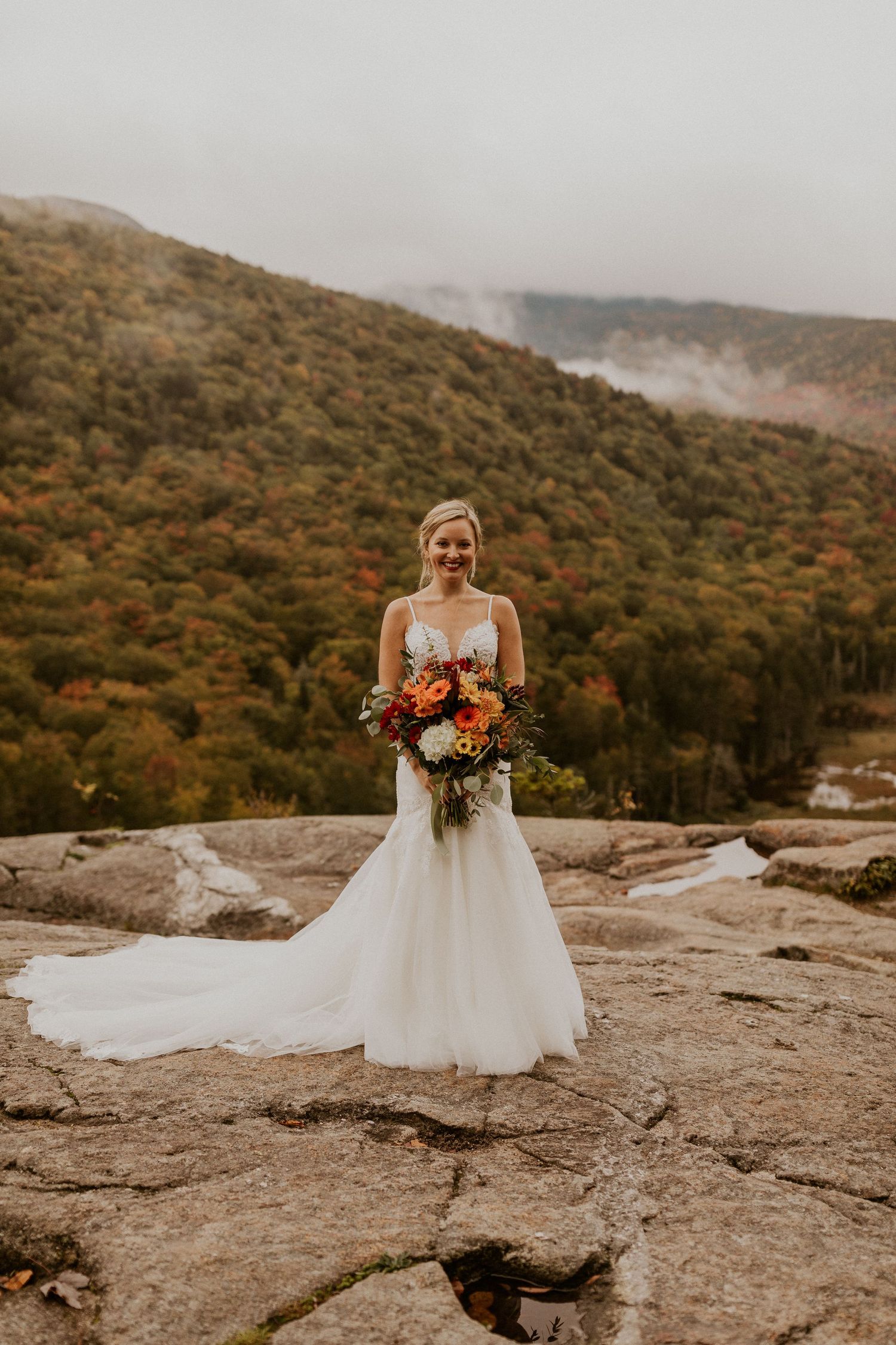 A full body portrait of the bride holding her bouquet.