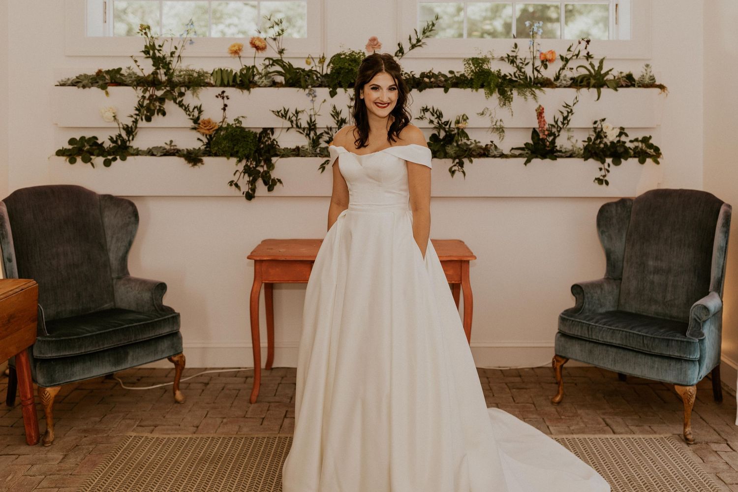 Wedding venue decorated with floral garlands and vintage furniture in a light-filled room.