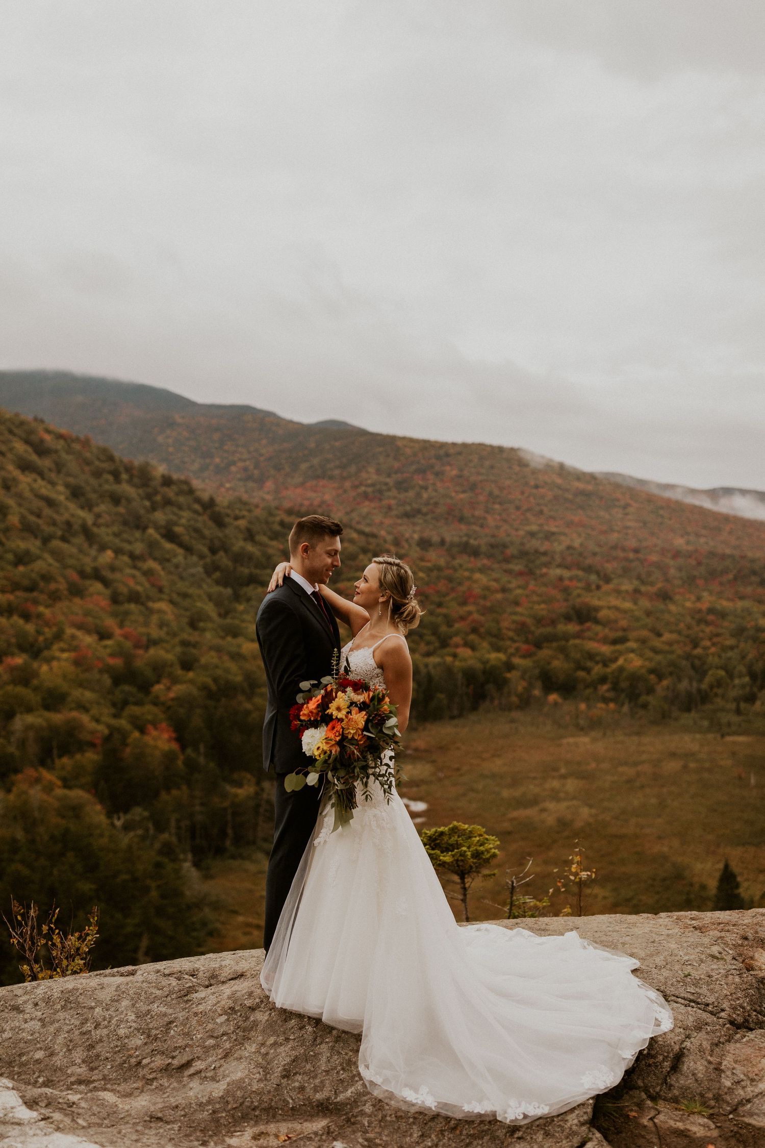 Newlyweds posing for mountaintop portraits in the White Mountain National Forest of New Hampshire.