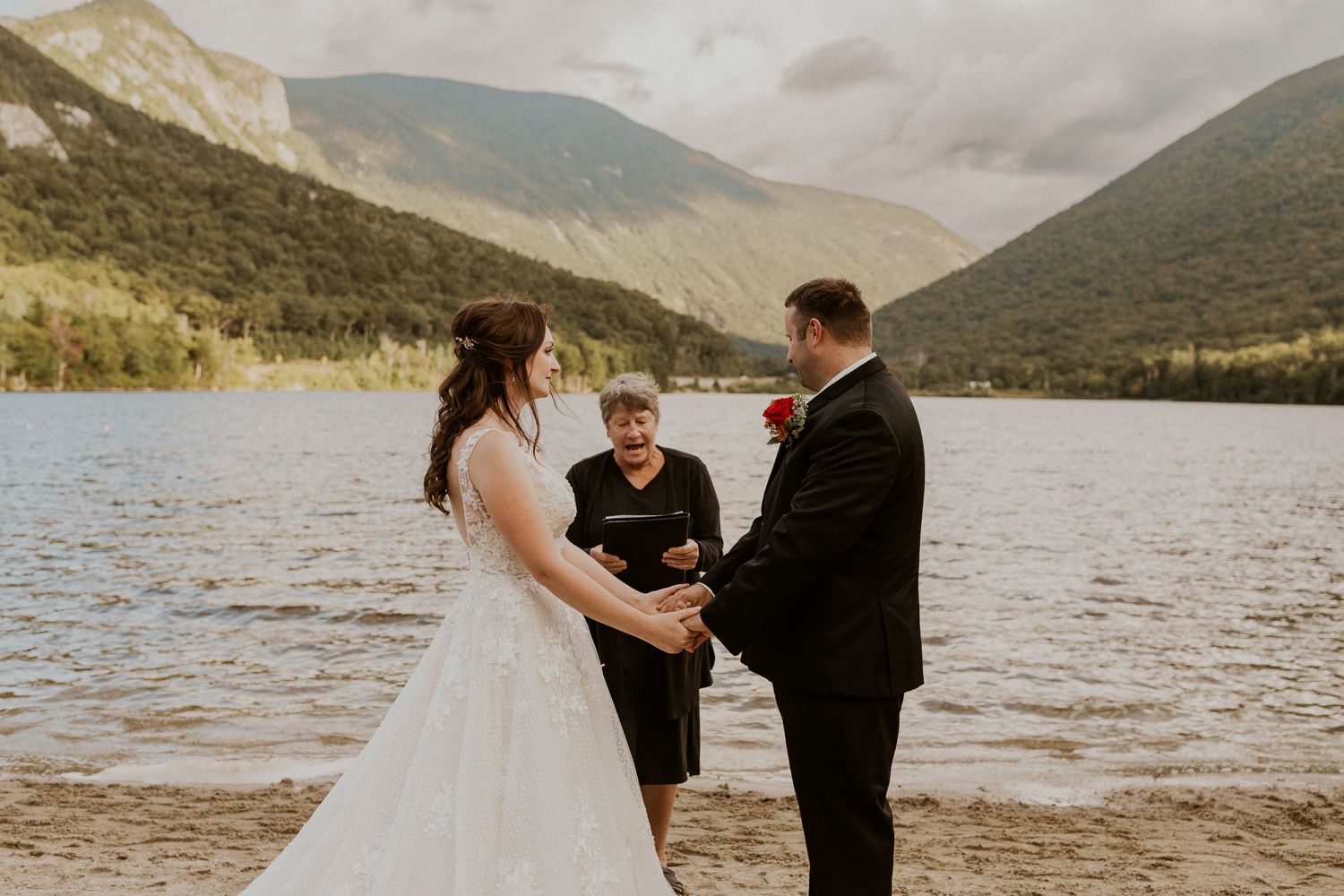 Bride and groom hold hands in front of the justice of the peace while declaring their love to each other.