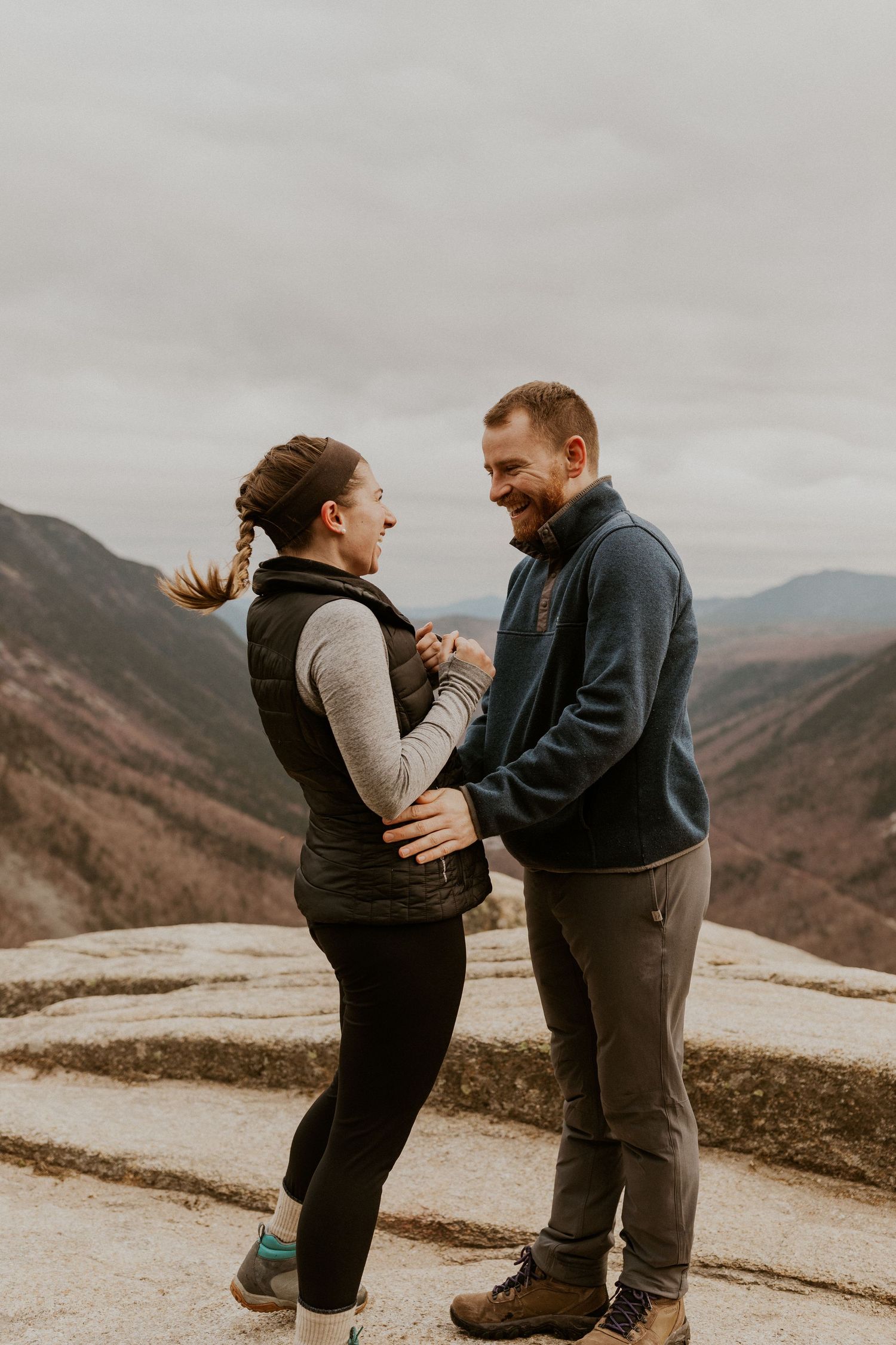 Newly engaged couple embracing each other on top of Mount Willard in the White Mountains of New Hampshire.