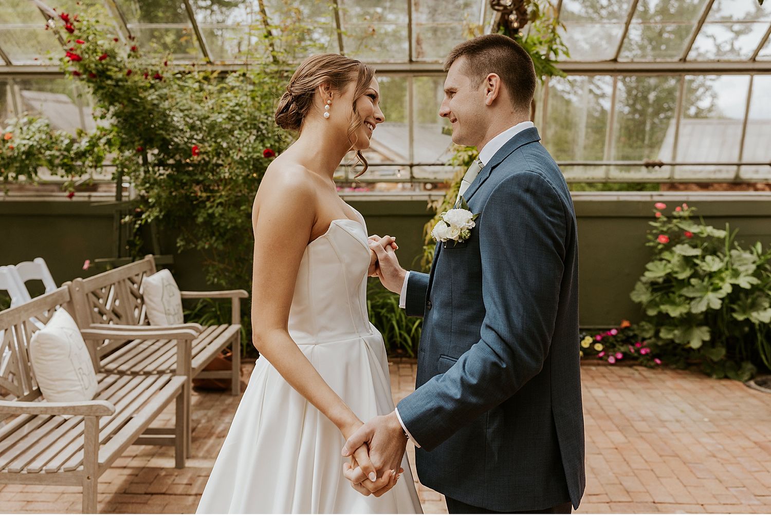 A couple shares their first look moment in a lush garden setting.