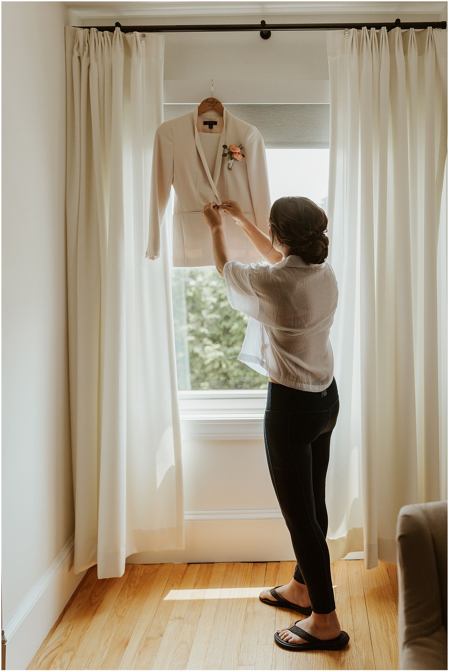Getting ready wedding photos of bride getting into her suit