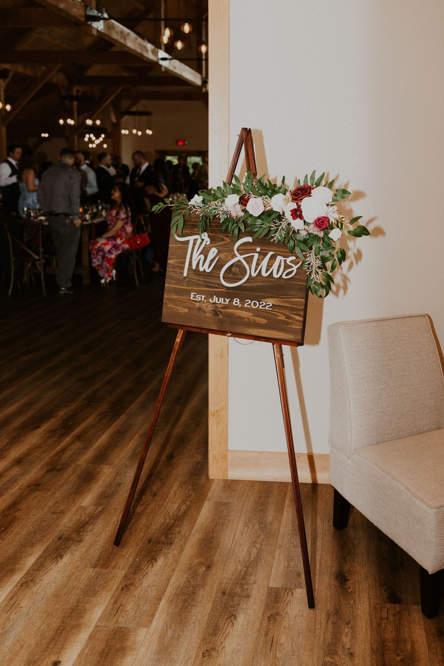 Rustic wooden wedding signs decorated with flowers and calligraphy displayed on easels.