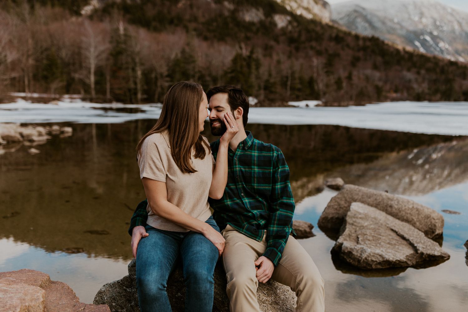 A happy couple standing in front of Echo Lake in Franconia Notch State Park