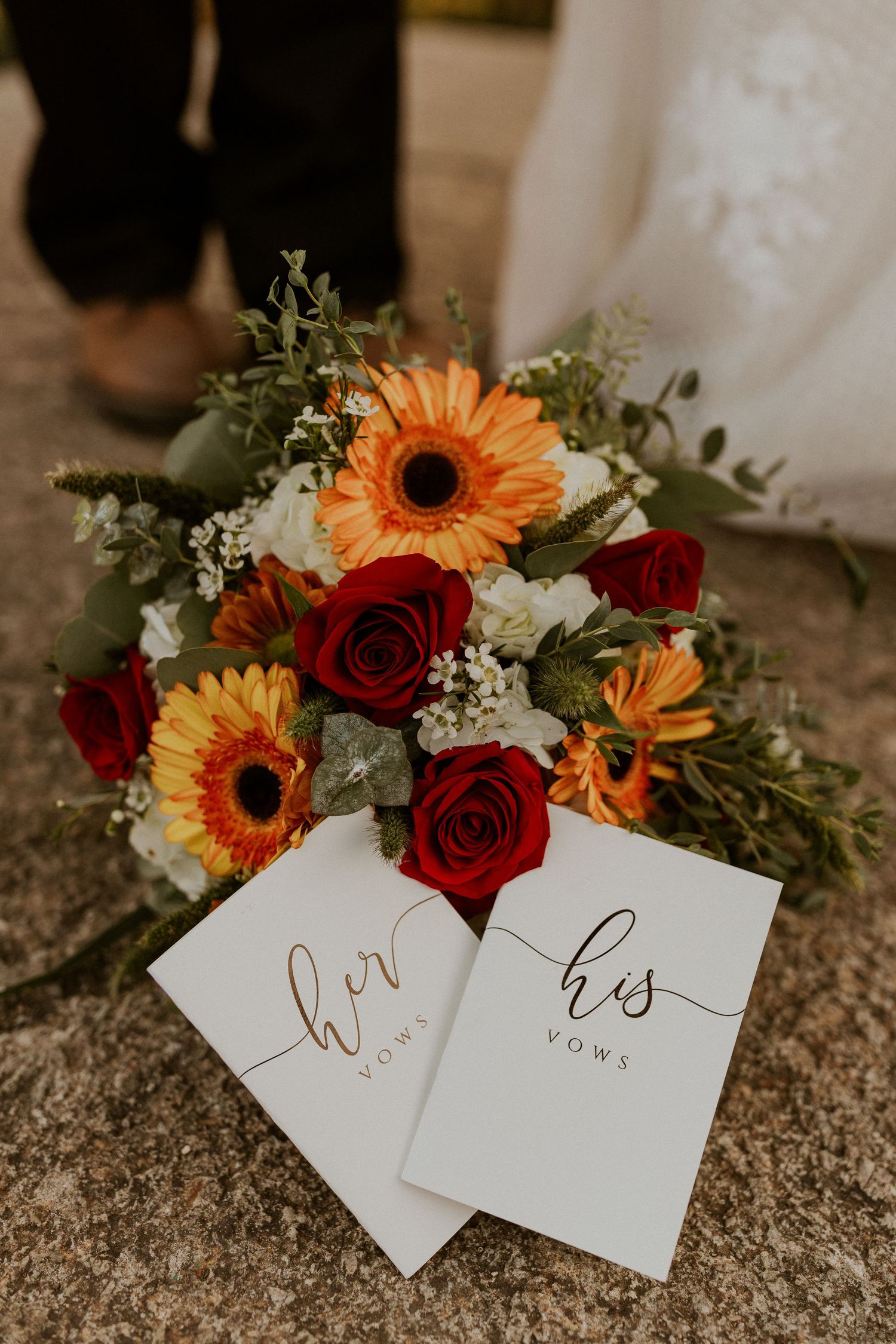 The couples vow books and bouquet of flowers.