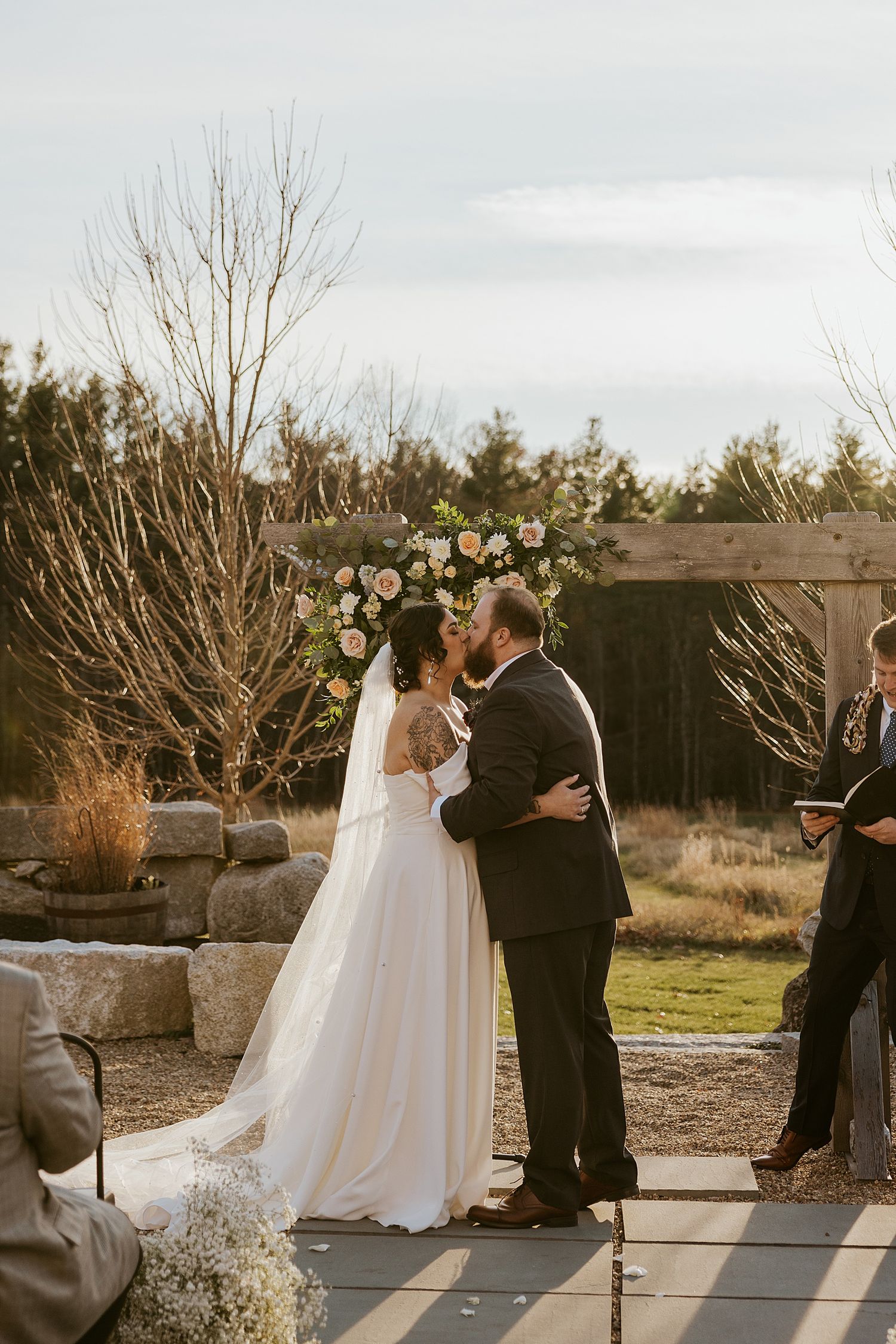 Bride and groom kissing at their New Hampshire wedding ceremony at the Barn at Powder Major's Farm