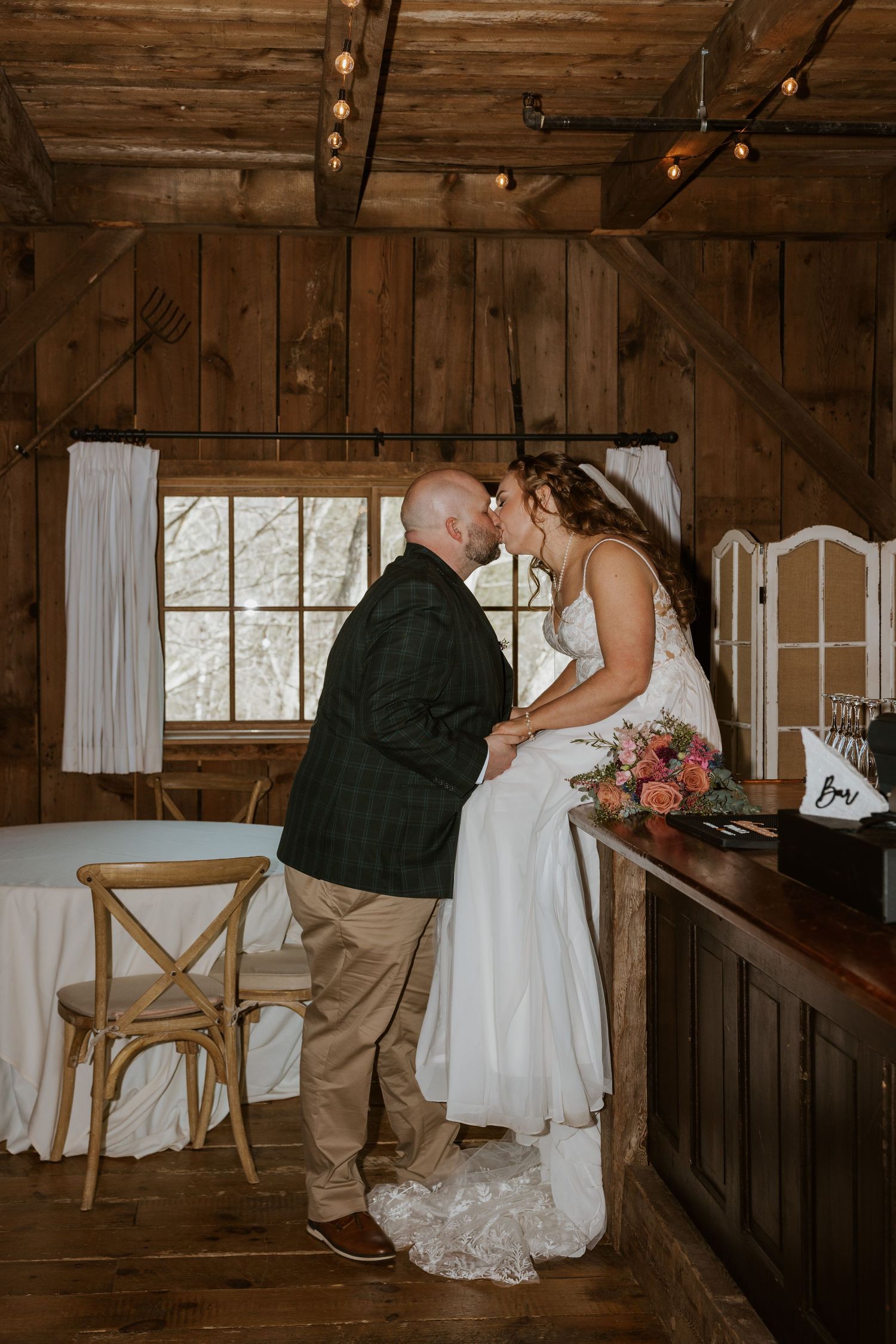 Intimate wedding ceremony moments captured in a rustic wooden barn setting with natural light.
