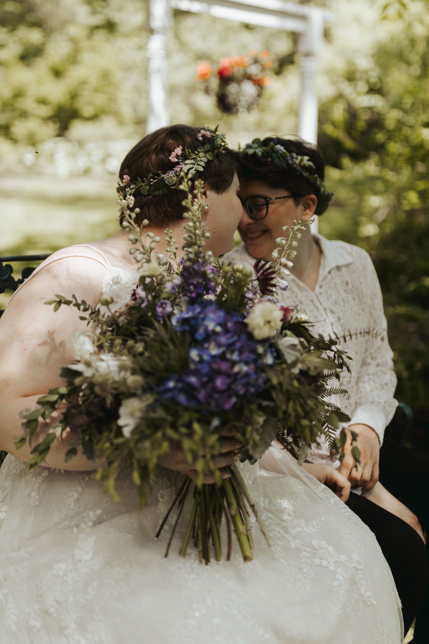 Wedding couple holding beautiful purple and white wildflower bouquets during their outdoor celebration.