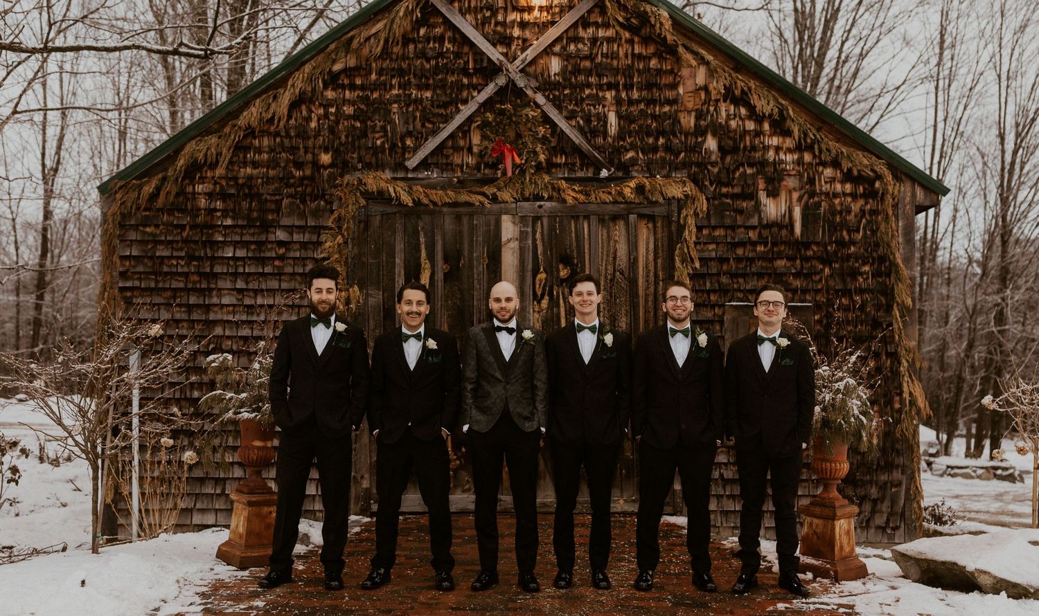 Brodie and the groomsmen posing for a portrait together in front of the sap house in Tamworth New Hampshire.