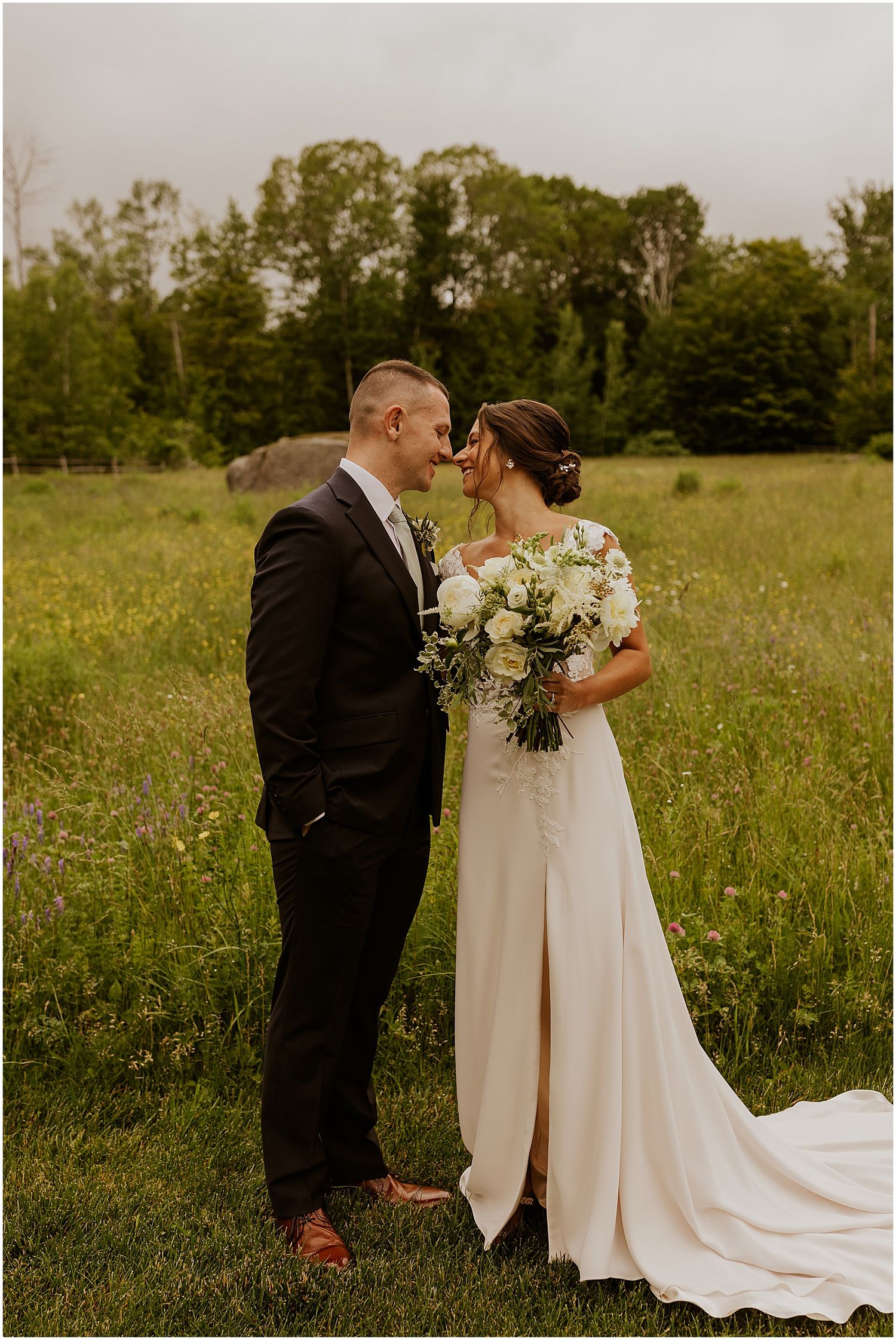 Romantic wedding couple shares intimate moments in a wildflower meadow with flowing white dress.