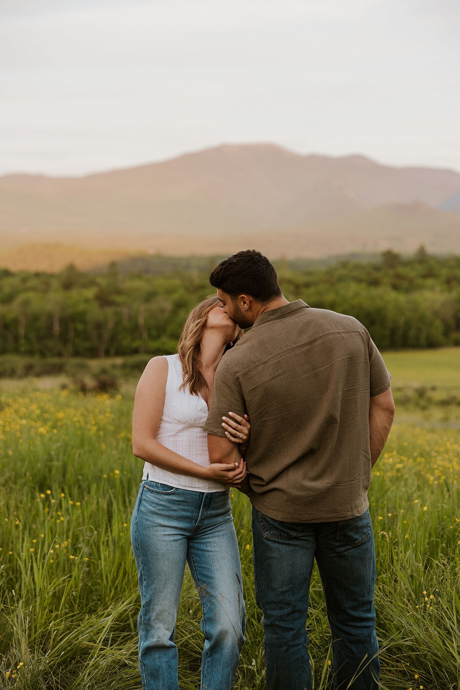 Couple kissing during their New Hampshire engagement photo session at golden hour