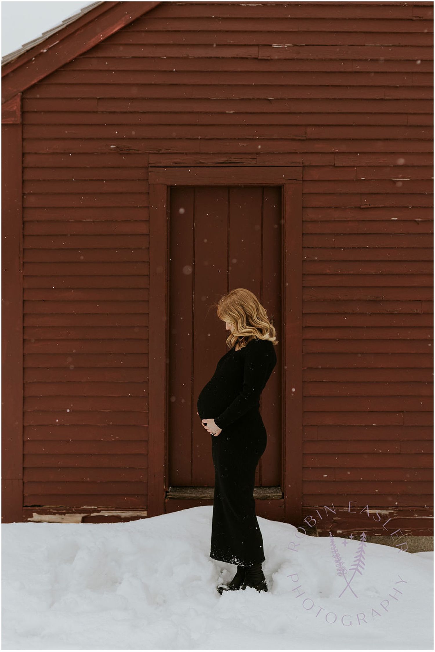 Figure in a black coat walks through deep snow towards a brown wooden door.