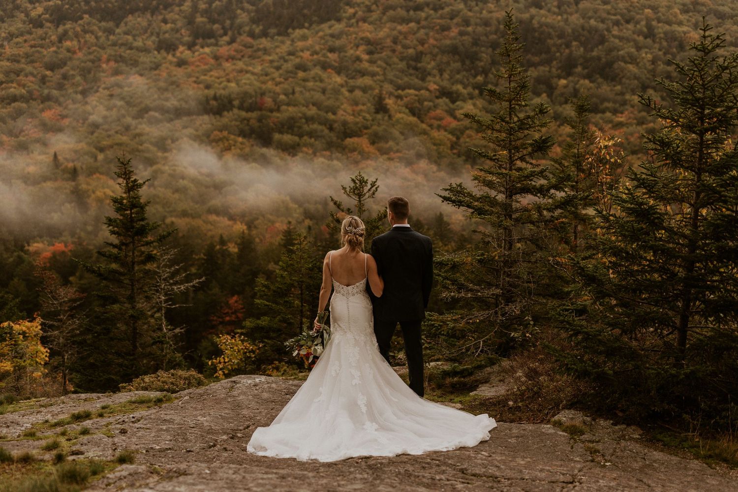 Newlyweds posing for mountaintop portraits in the White Mountain National Forest of New Hampshire.