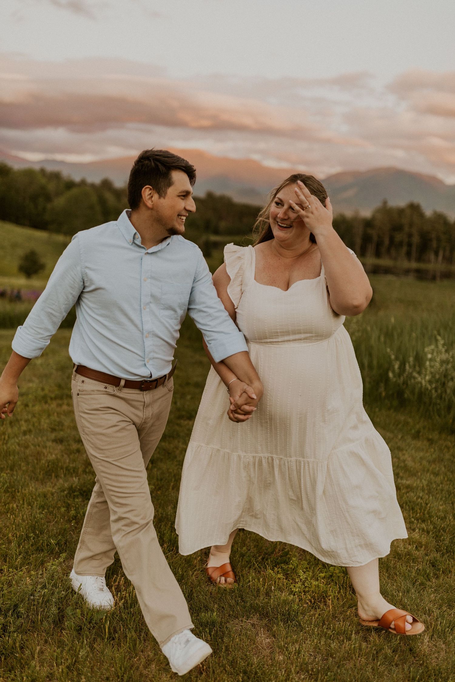 Terise and Jose playfully walking together in a lupine field in Sugar Hill NH during their engagement photos.
