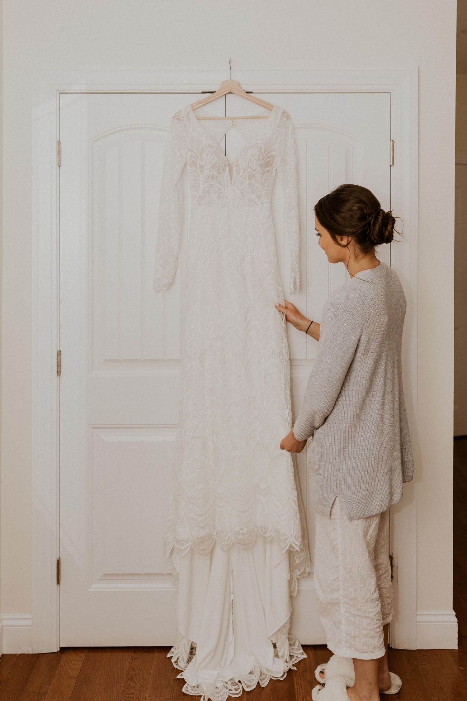 Abbie, the bride, admiring her wedding dress before putting it on.