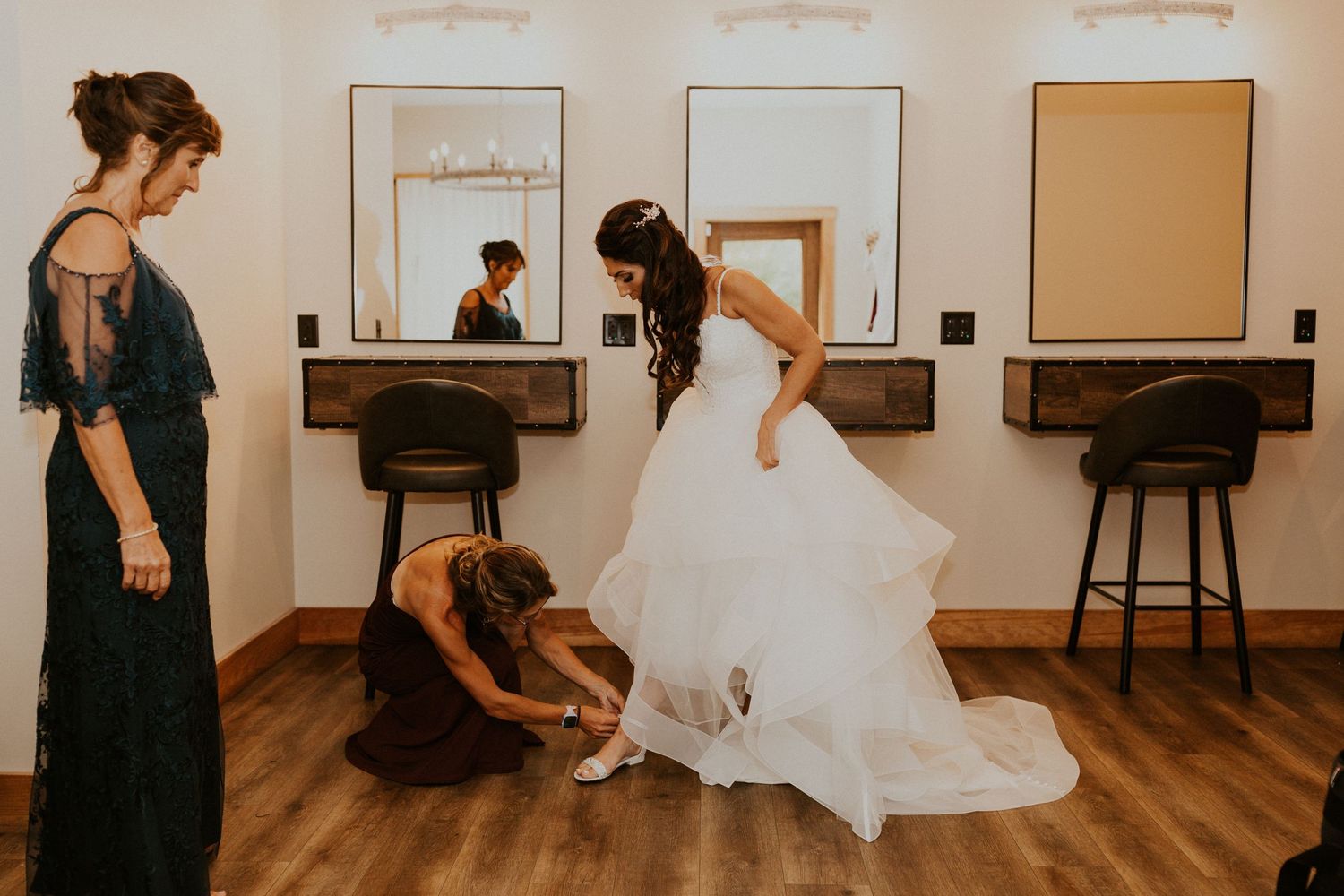 Jessica's cousin helping her put on her shoes once she is dressed.