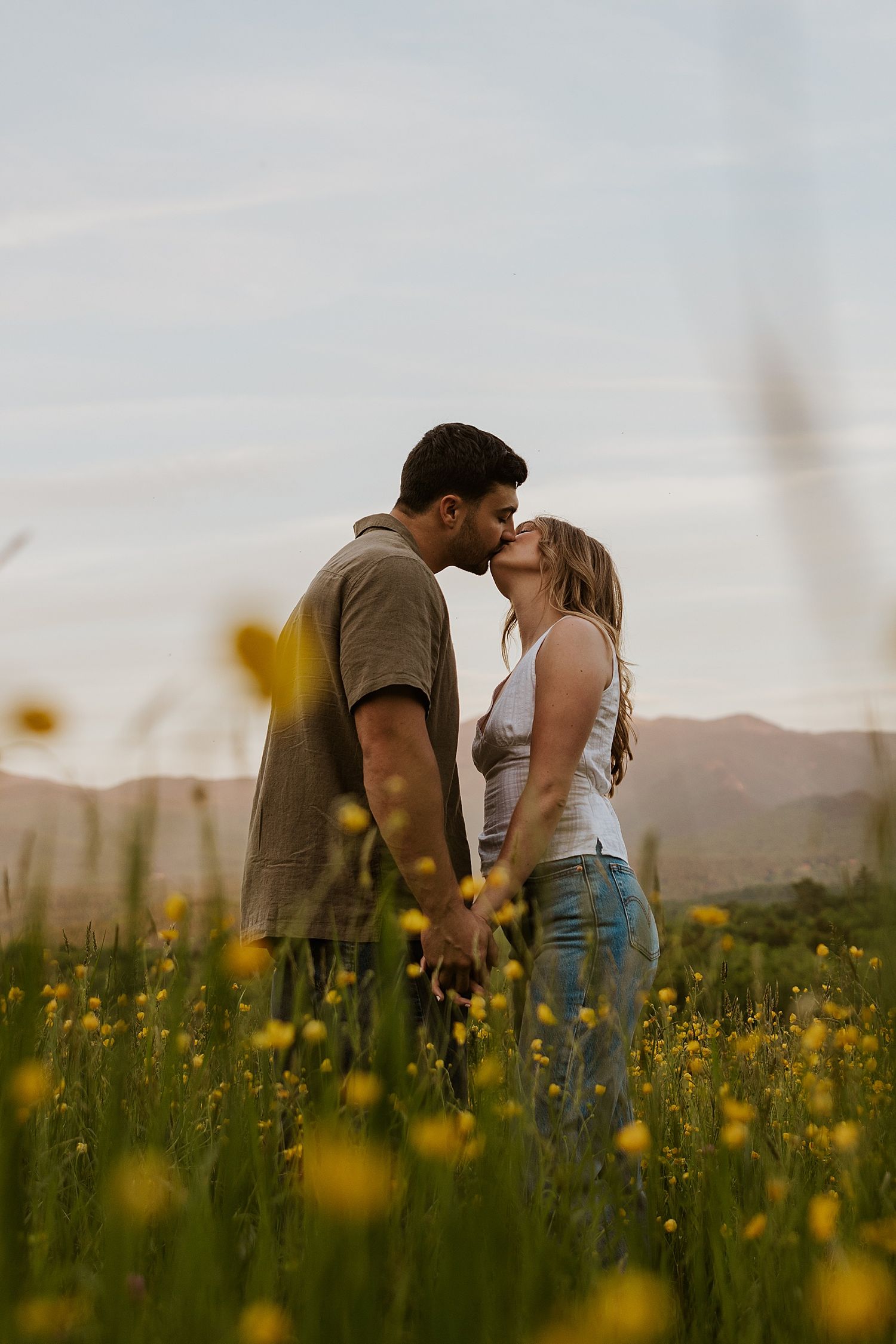 Couple taking engagment photos at sunset in a wildflower field in New Hampshire