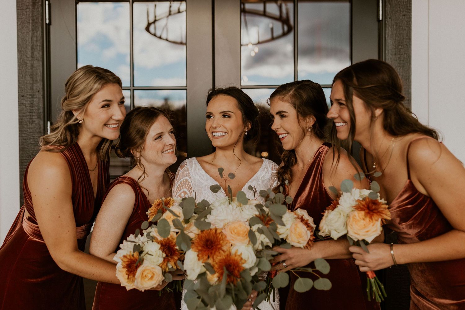 Abbie and her bridesmaids snuggled in close for a portrait together! Everyone is smiling and laughing.