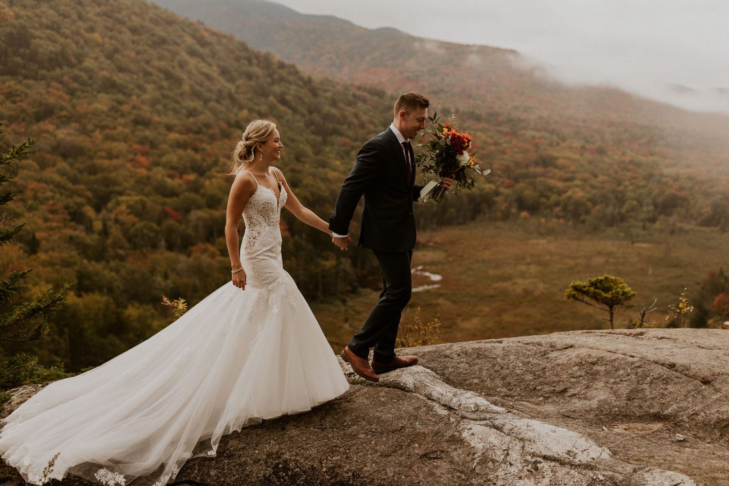 Newlyweds posing for mountaintop portraits in the White Mountain National Forest of New Hampshire.