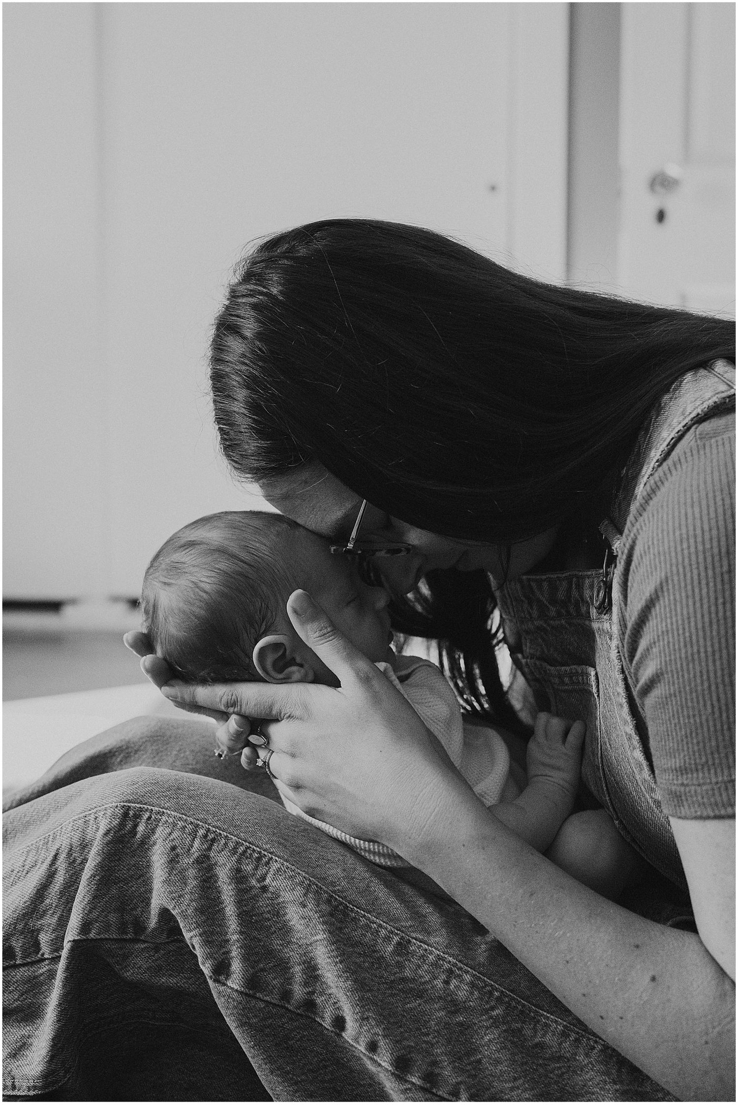 Black and white portrait of a NH mom cuddling her newborn baby