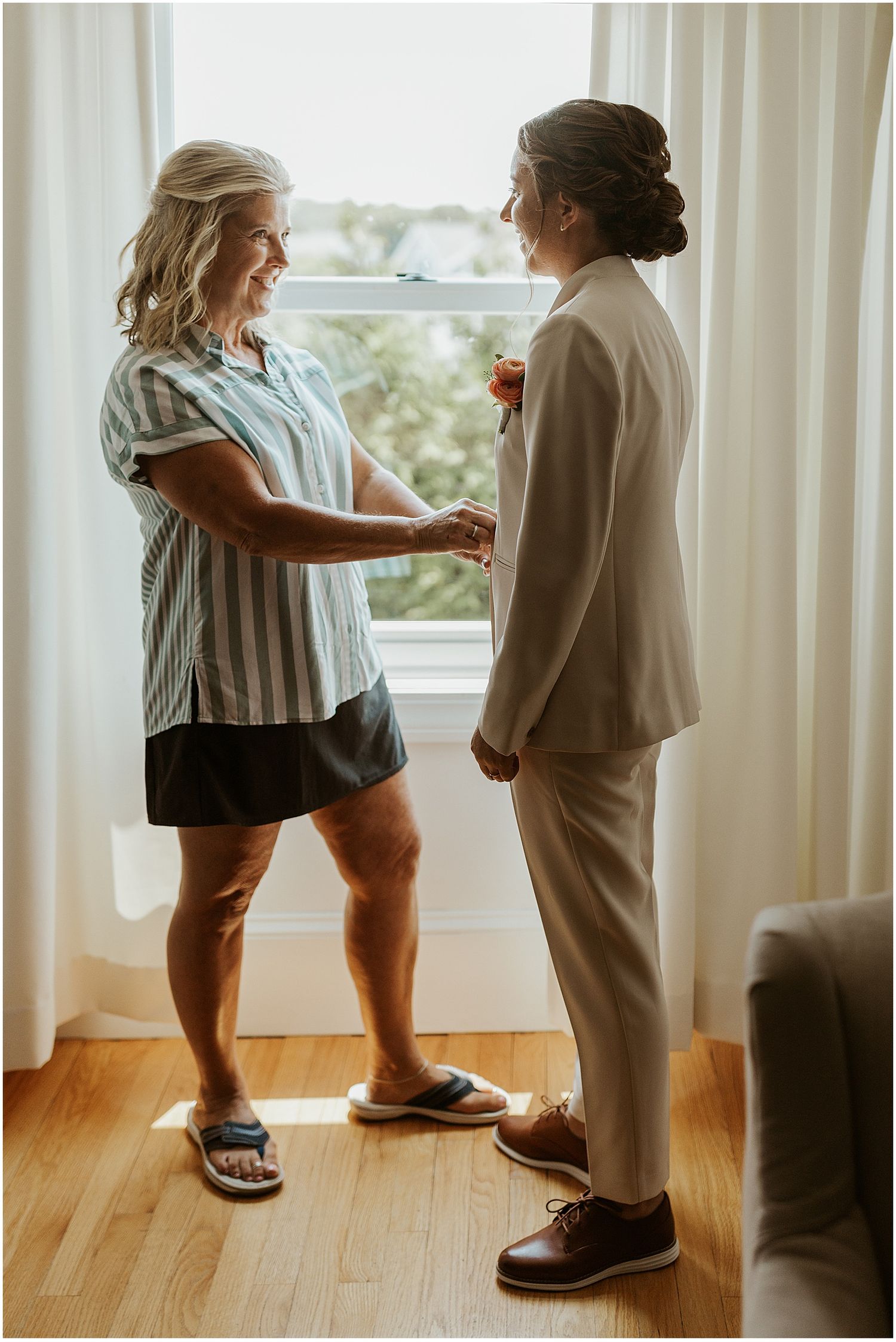 Getting ready wedding photos of bride getting dressed in her suit